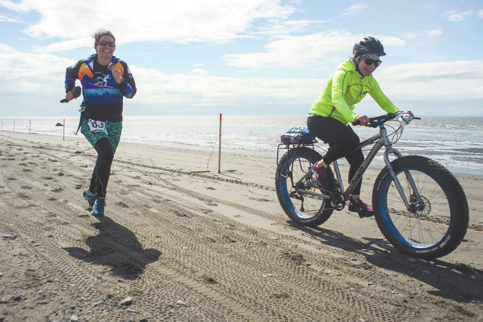 Photo courtesy Kaitlin Vadla                                Heather Renner and Tasha Reynolds run and fat bike to the finish line on the Kenai Beach during the 2019 Mouth to Mouth Wild Run & Ride.