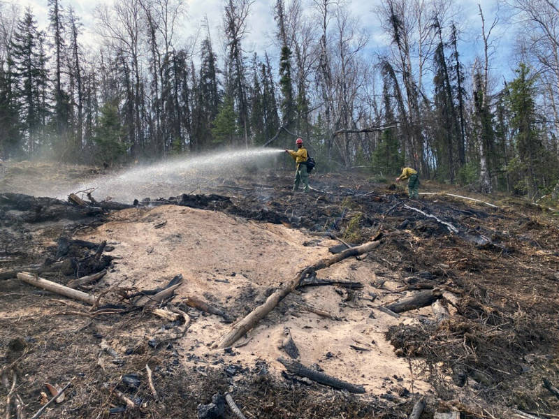 Firefighters from the Mat-Su Area State Forestry office hose down a small wildfire on May 3, 2020. The fire was started by an escaped contractor debris pile that had burned several days prior but flared up Sunday and caught nearby grass on fire. (Alaska Division of Forestry)