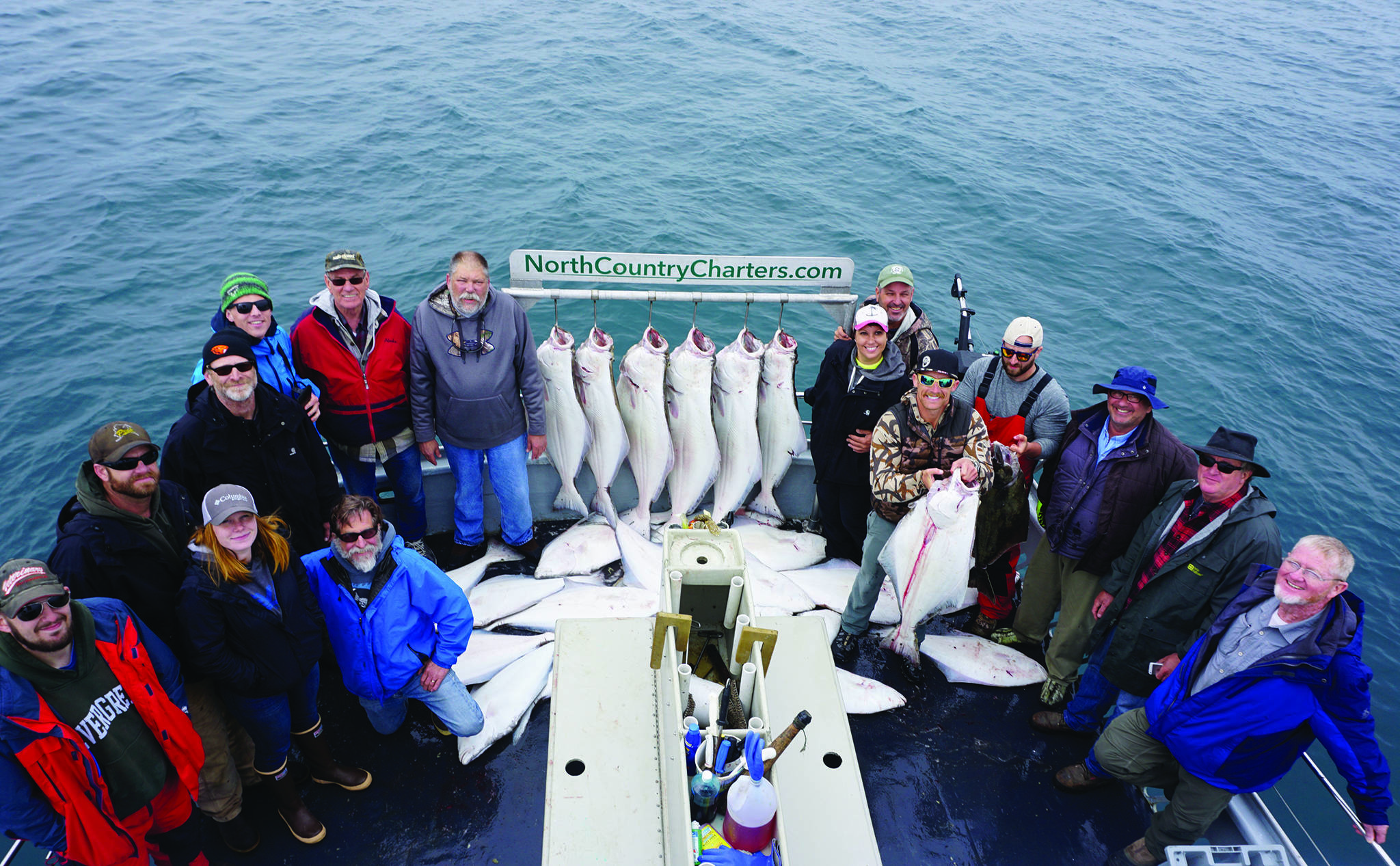 Michael Armstrong / Homer News file                                 Anglers stand by a rack of halibut on the Irish as the North Country Charters boat returned to Homer in July 2017.