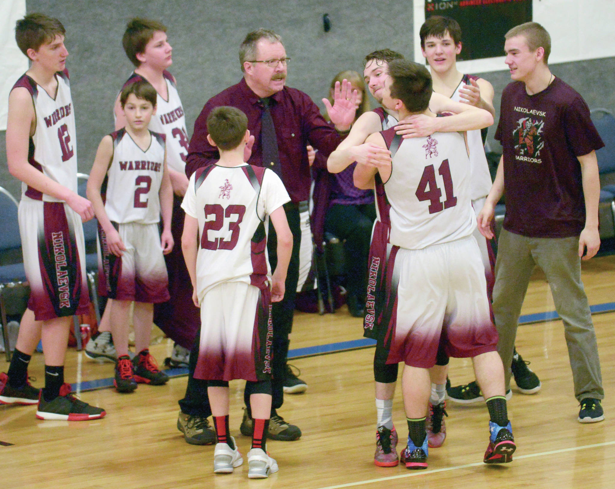 Jeff Helminiak / Peninsula Clarion file                                Nikolaevsk coach Steve Klaich celebrates with his team after winning his first Peninsula Conference title in his 30th season at the helm March 1, 2019, at Cook Inlet Academy in Soldotna.