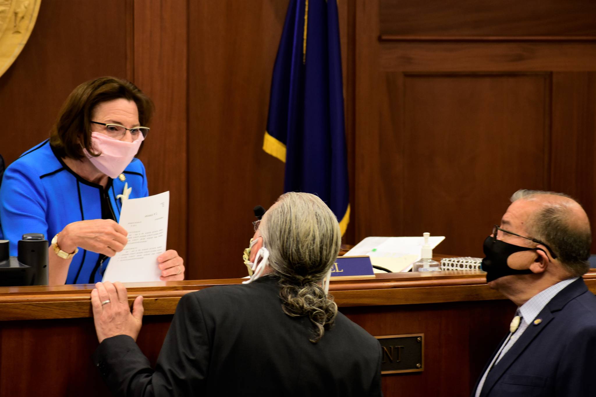 Senate President Cathy Giessel, R-Anchorage, speaks with Sens. Tom Begich, D-Anchorage, and Lyman Hoffman, D-Bethel, before the start of the floor session on Wednesday, May 20, 2020. Senators remained in Juneau to vote on a bill passed by the House Tuesday ratifying Gov. Mike Dunleavy’s distribution of federal relief money. (Peter Segall | Juneau Empire)