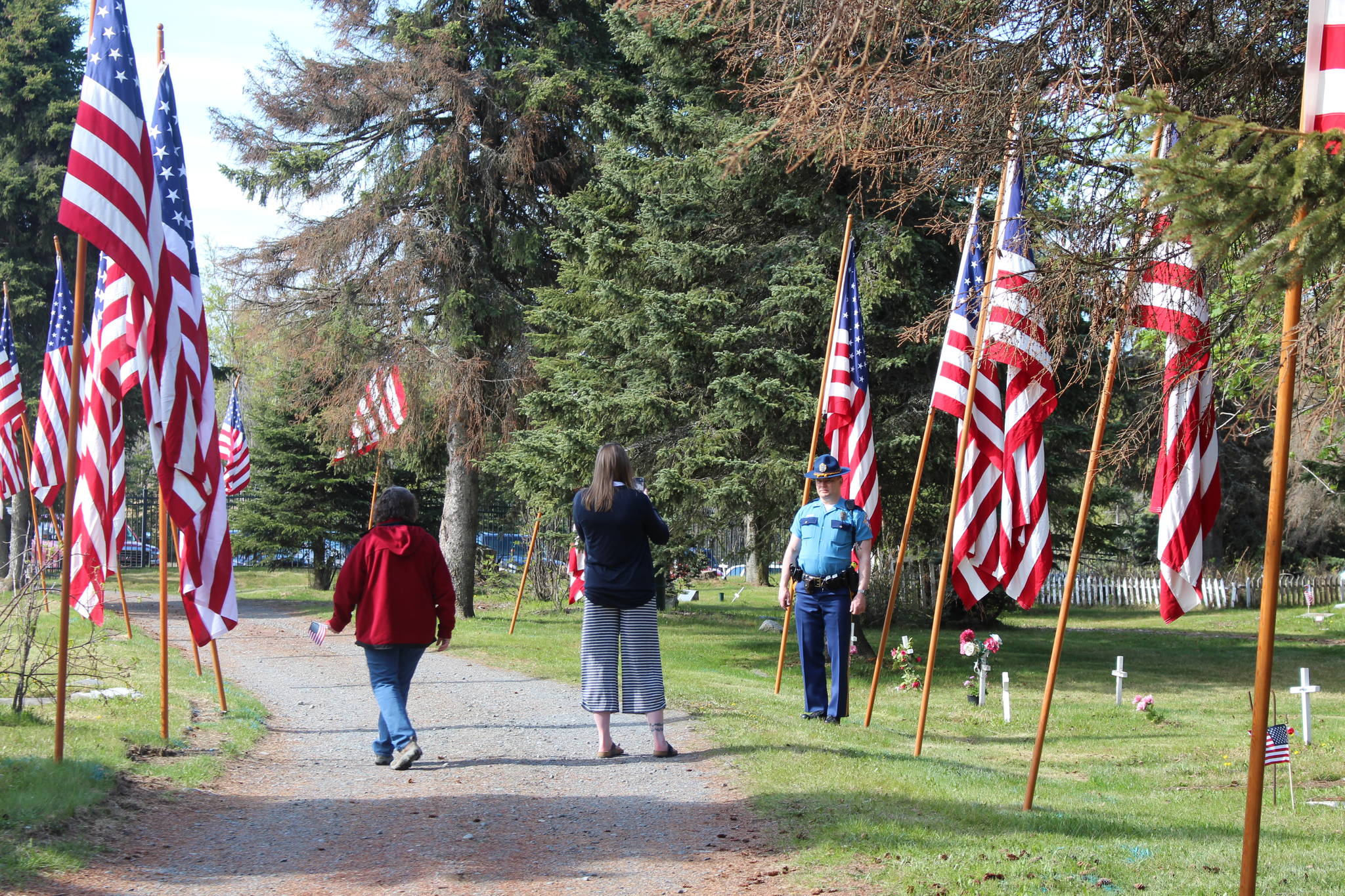 Kenai residents take a moment to honor fallen veterans during the Memorial Day ceremony at the Kenai Cemetery on May 25, 2020. (Photo by Brian Mazurek/Peninsula Clarion)