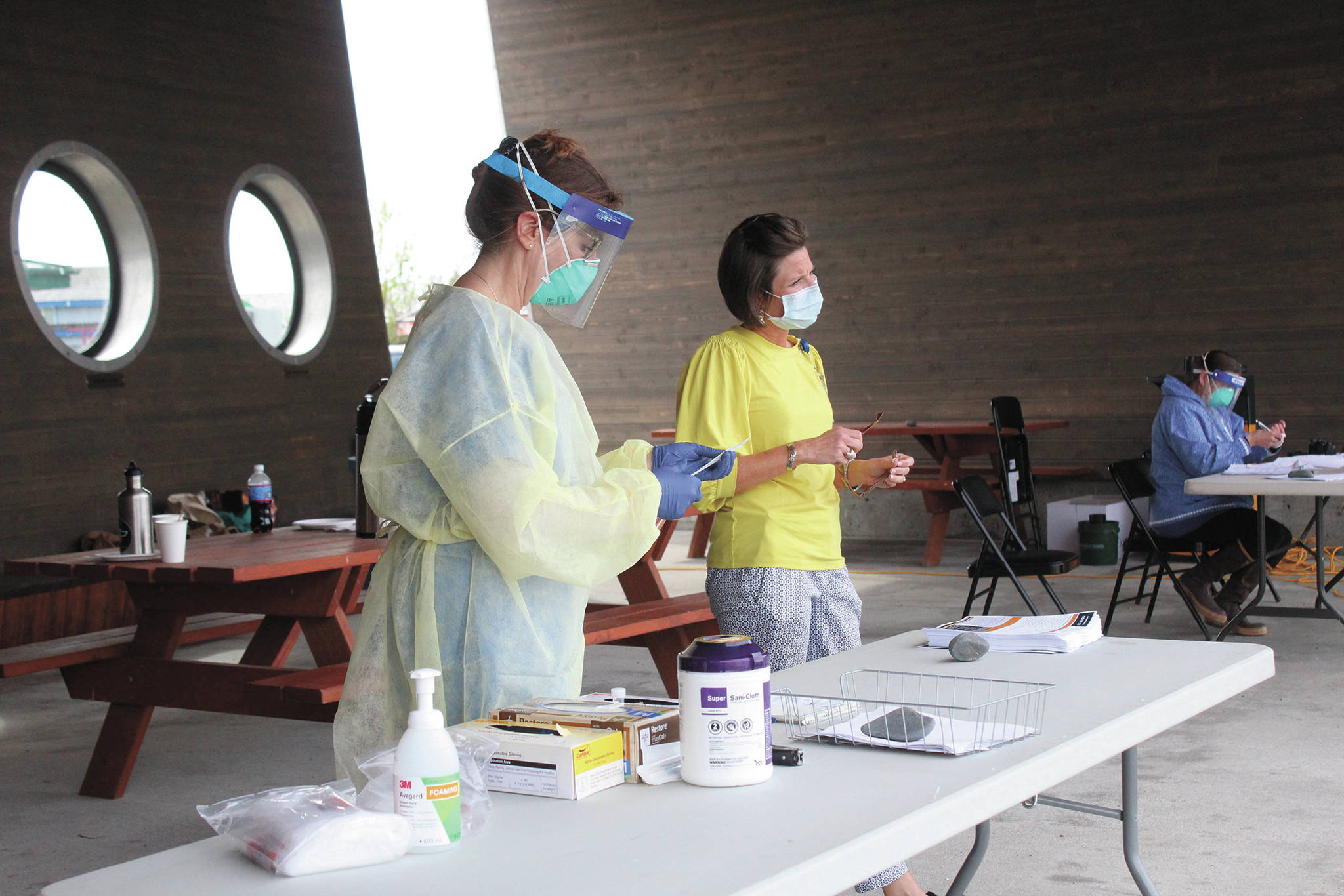 Registered Nurse Cathy Davis (left) and Chief Nursing Officer Dawn Johnson (right) work at a table to get COVID-19 tests ready for the public Friday, May 29, 2020 at the Boat House Pavilion on the Homer Spit in Homer, Alaska. South Peninsula Hospital is now offering free COVID-19 testing for asymptomatic people with no appointments necessary at the Boat House Pavilion through June 6. (Photo by Megan Pacer/Homer News)