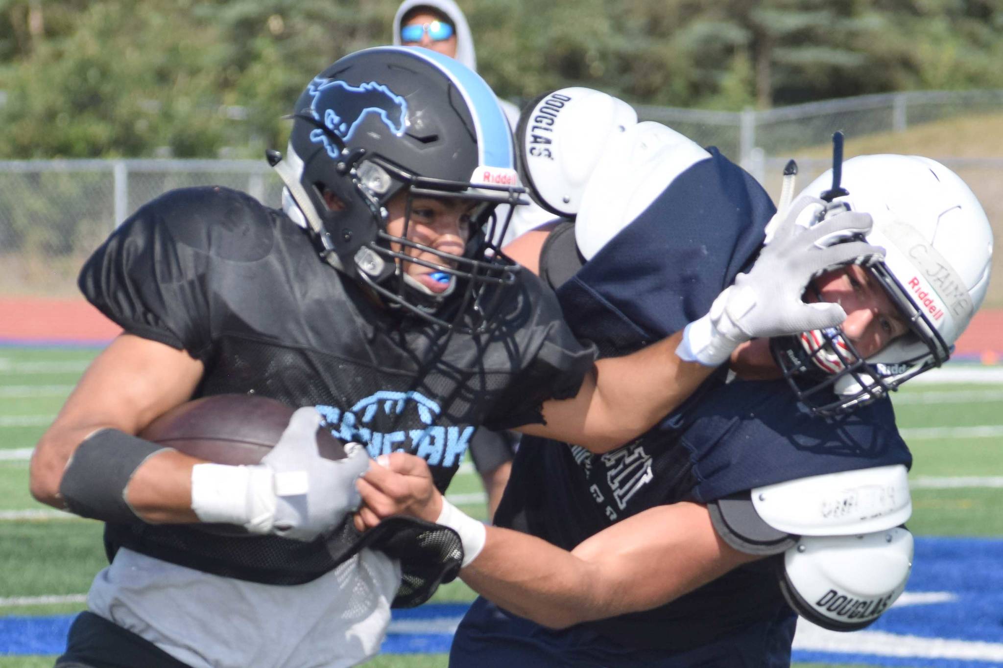 Chugiak’s Tyler Huffer stiff-arms Soldotna’s Hudson Metcalf during a scrimmage Saturday, Aug. 10, 2019, at Justin Maile Field in Soldotna, Alaska. (Photo by Jeff Helminiak/Peninsula Clarion)
