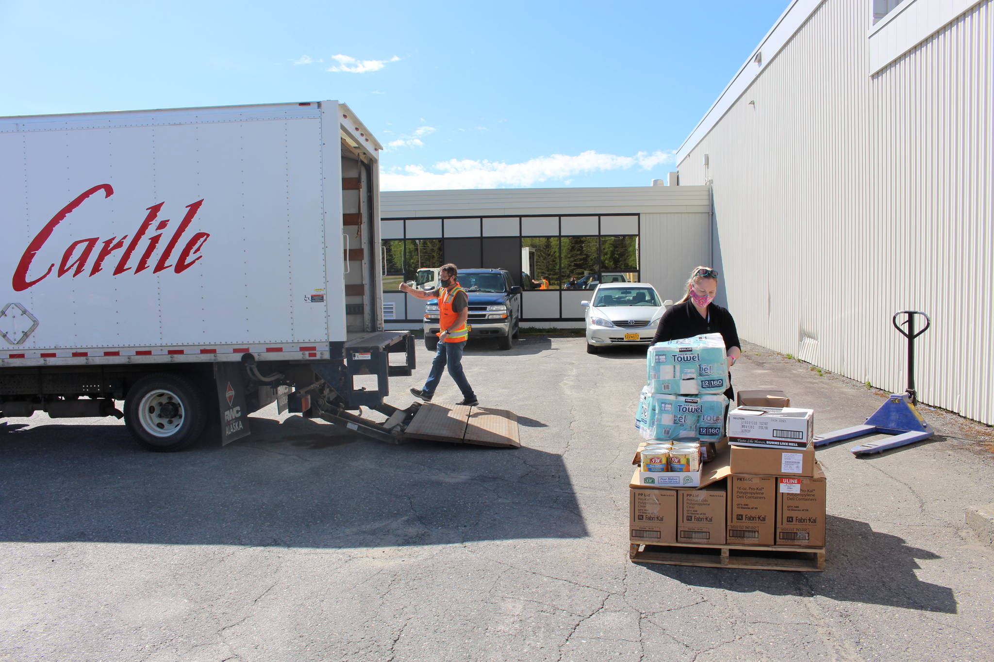 Kenai Peninsula Boys & Girls Clubs CEO Rachel Chaffee, right loads up a pallet with goods that Carlile driver Robert Ivy will take back to Carlile’s Kenai headquarters, where it will then be transported to Anchorage and ultimately Seward, at Kenai Central High School in Kenai, Alaska on May 28, 2020. (Photo by Brian Mazurek/Peninsula Clarion)