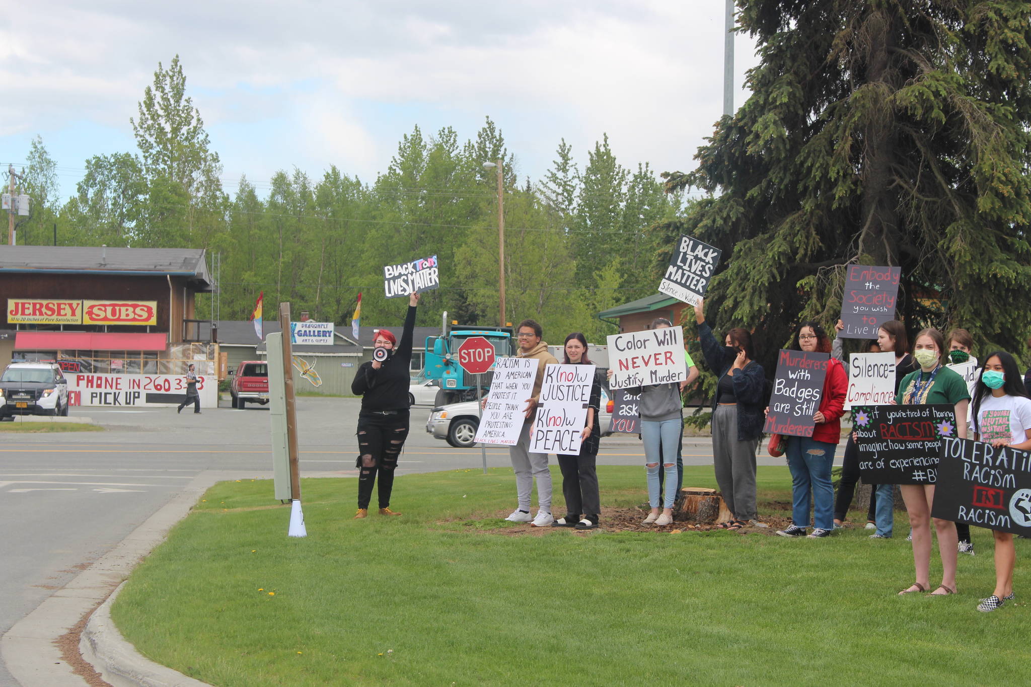 Participants in a Black Lives Matters protest hold signs at the entrance to Soldotna Creek Park along the Sterling Highway in Soldotna on Wednesday. (Photo by Brian Mazurek/Peninsula Clarion)