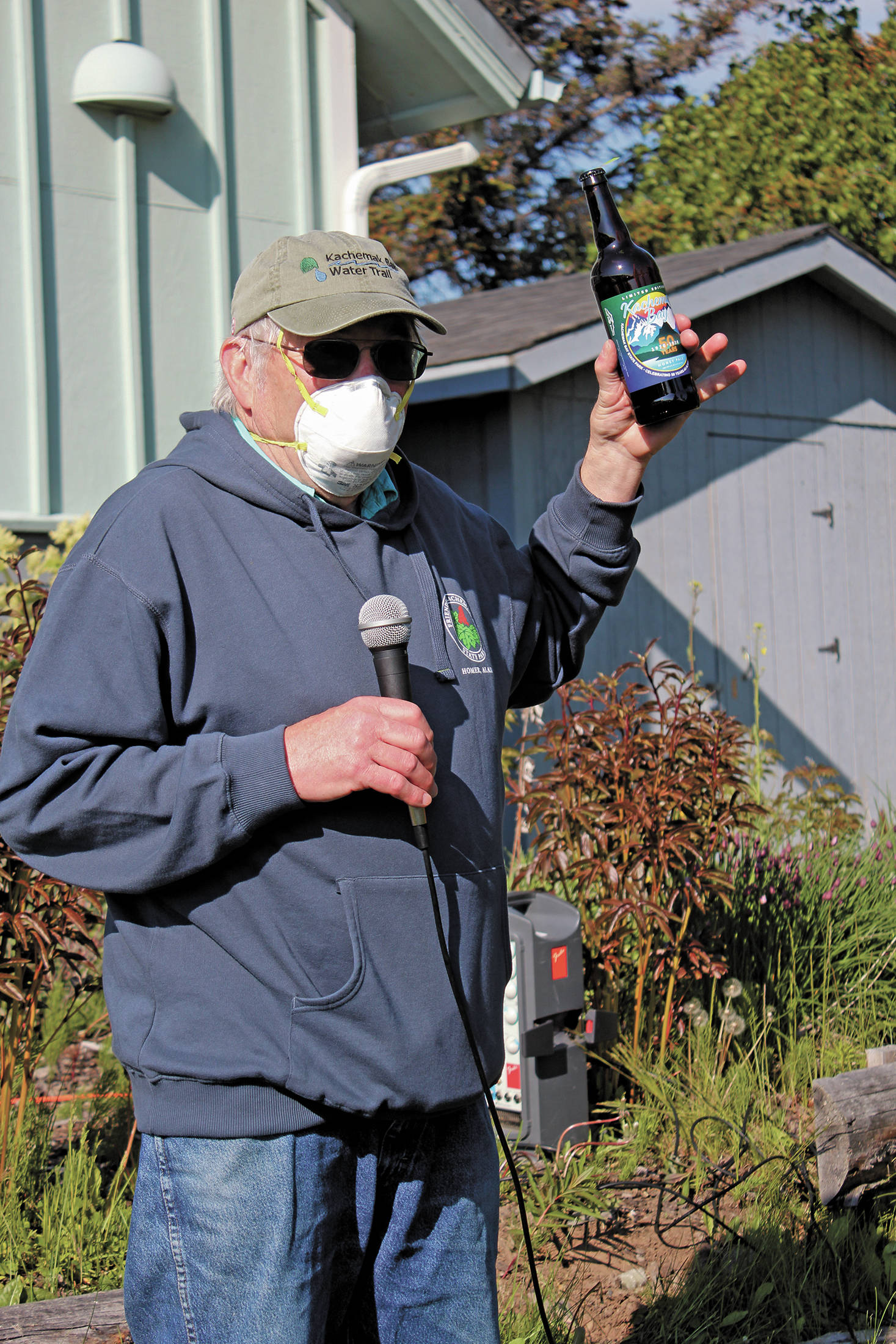 Robert Archibald auctions off one of the last two bottles of limited edition beer created by Grace Ridge Brewery to celebrate the 50th anniversary of Kachemak Bay State Park during a gathering Saturday, June 6, 2020 at the Homer Chamber of Commerce & Visitor Center in Homer, Alaska. (Photo by Megan Pacer/Homer News)