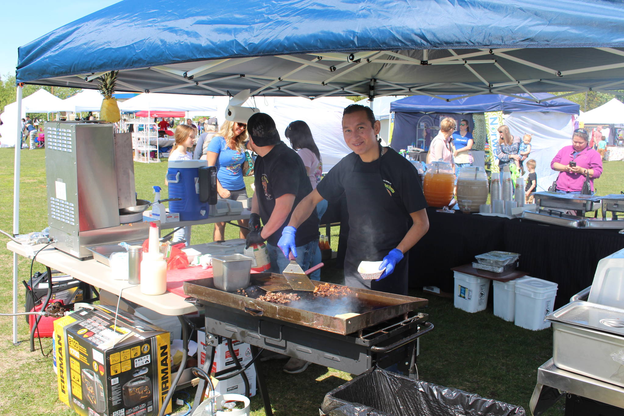 Freddy Delgado, left, and Oscar Martinez, right, chefs at Senor Panchos, cook up el pastor and carne asada tacos during the Wednesday Market at Soldotna Creek Park in Soldotna, Alaska on June 10, 2020. (Photo by Brian Mazurek/Peninsula Clarion)