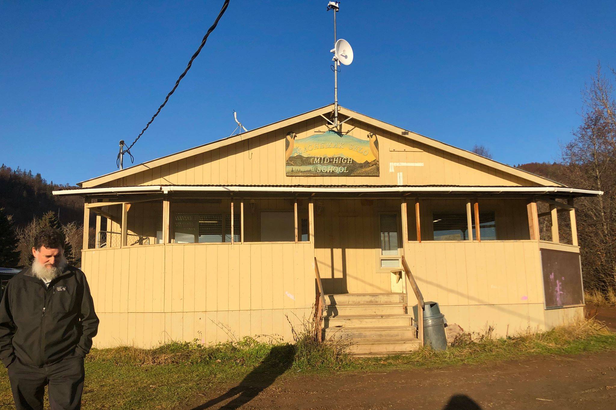 Principal Michael Wojciak stands in front of the middle and high school building of Kachemak Selo School Nov. 12, 2019, in Kachemak Selo, Alaska. (Photo by Victoria Petersen/Peninsula Clarion)