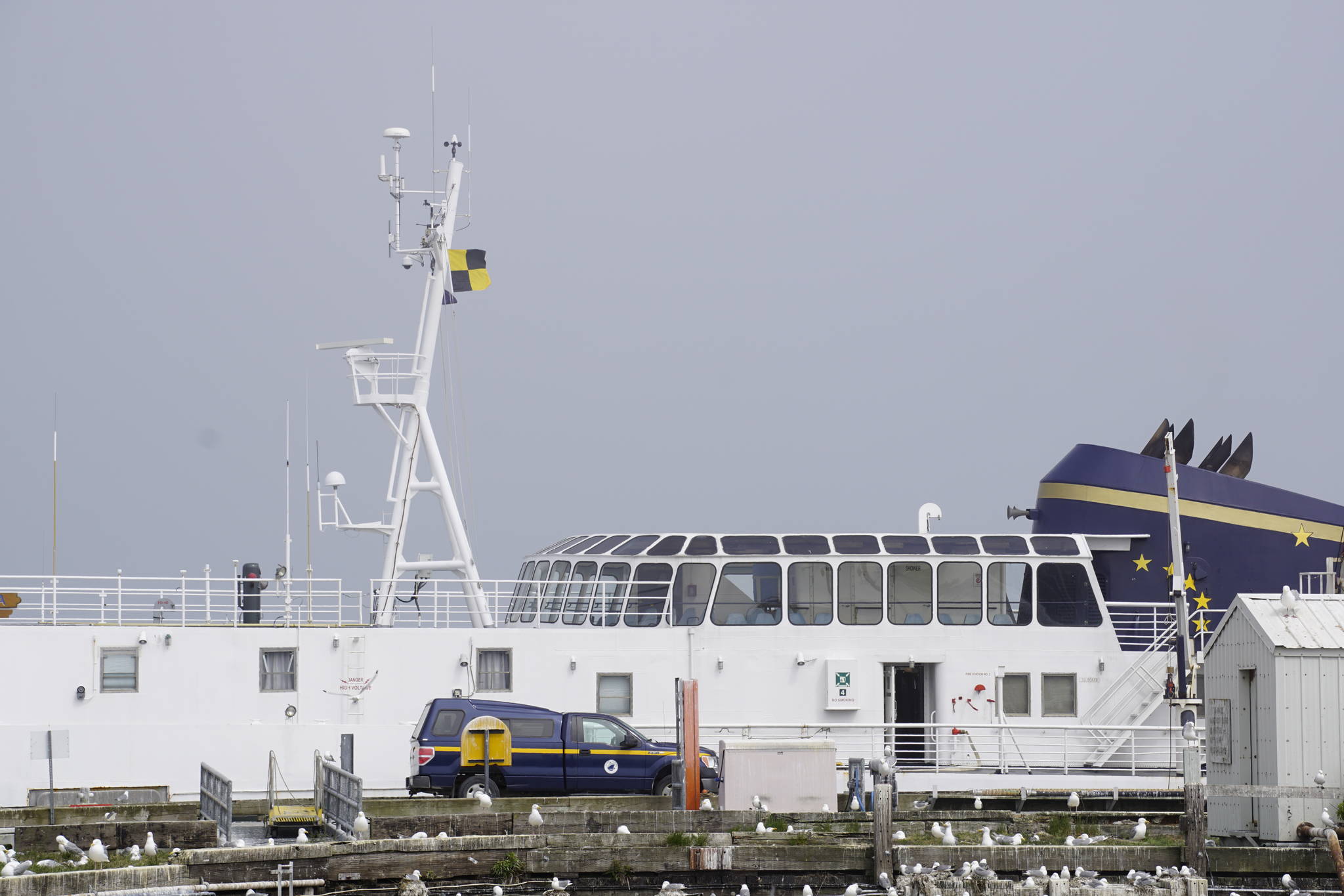 A quarantine or “Lima” flag of yellow-and-black flies from the M/V Tustumena on Friday, June 12, 2020, at the Pioneer Dock in Homer, Alaska. Seven crew members tested positive for COVID-19, and as of Friday three of them remained quarantined on the state ferry. (Photo by Michael Armstrong/Homer News)