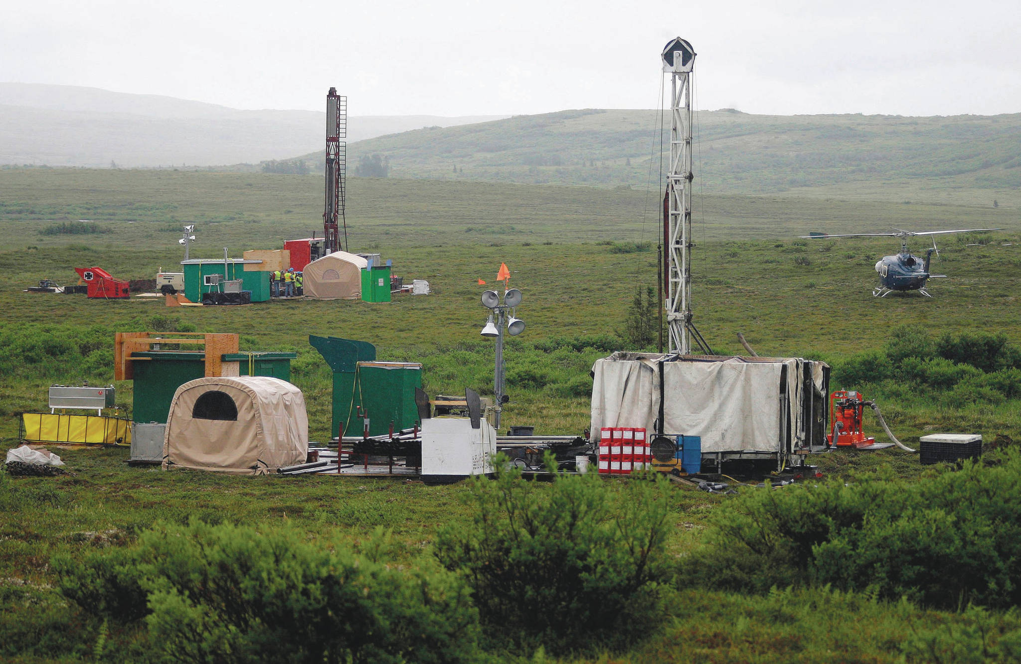 In this July 13, 2007, file photo, workers with the Pebble Mine project test drill in the Bristol Bay region of Alaska, near the village of Iliamma. The Pebble Limited Partnership, which wants to build a copper and gold mine near the headwaters of a major U.S. salmon fishery in southwest Alaska, says it plans to offer residents in the region a dividend. (AP Photo/Al Grillo, File)