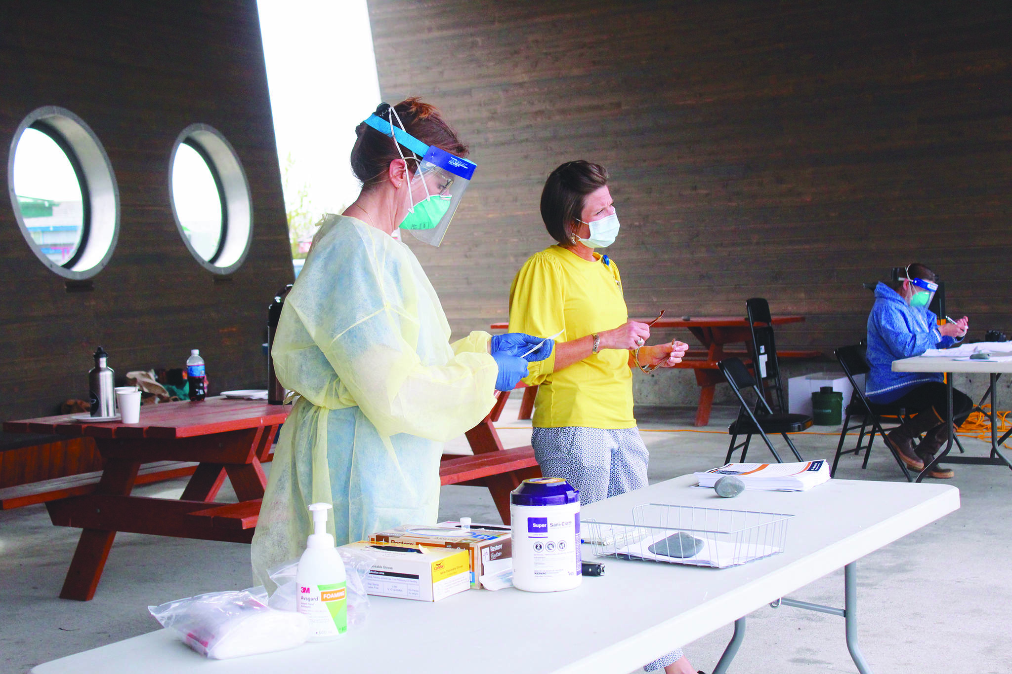 Registered Nurse Cathy Davis (left) and Chief Nursing Officer Dawn Johnson (right) work at a table to get COVID-19 tests ready for the public Friday, May 29, 2020 at the Boat House Pavilion on the Homer Spit in Homer, Alaska. South Peninsula Hospital is now offering free COVID-19 testing for asymptomatic people with no appointments necessary at the Boat House Pavilion through June 6. (Photo by Megan Pacer/Homer News)