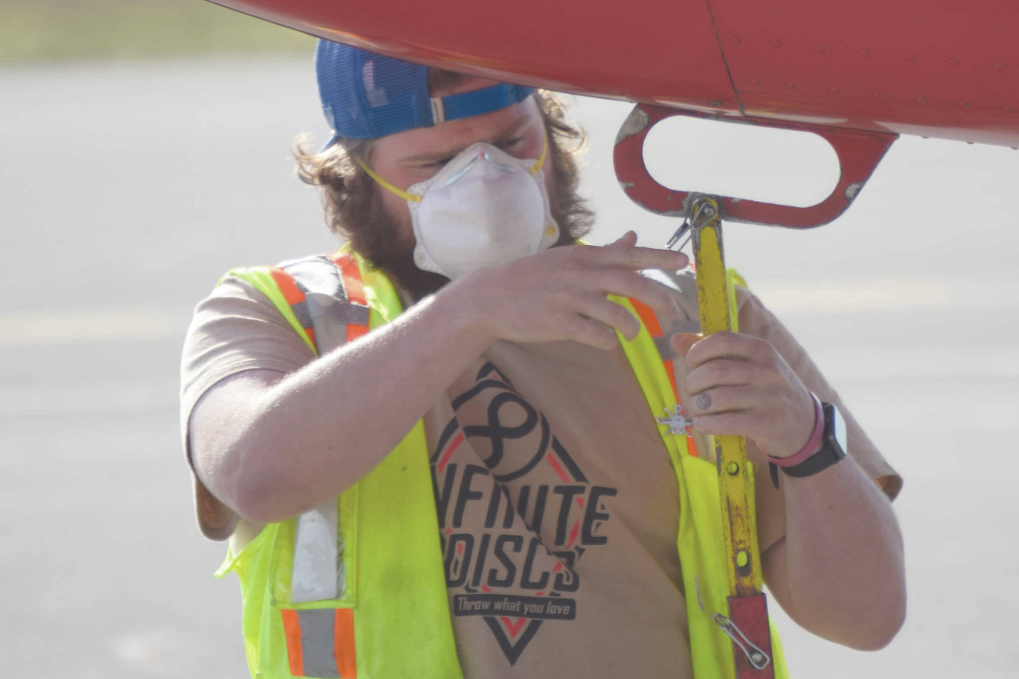 Soldotna’s Chase Gable, a customer service agent with Grant Aviation, prepares to load and unload baggage from a plane at Kenai Municipal Airport on Tuesday, June 30, 2020, in Kenai, Alaska. (Photo by Jeff Helminiak/Peninsula Clarion)