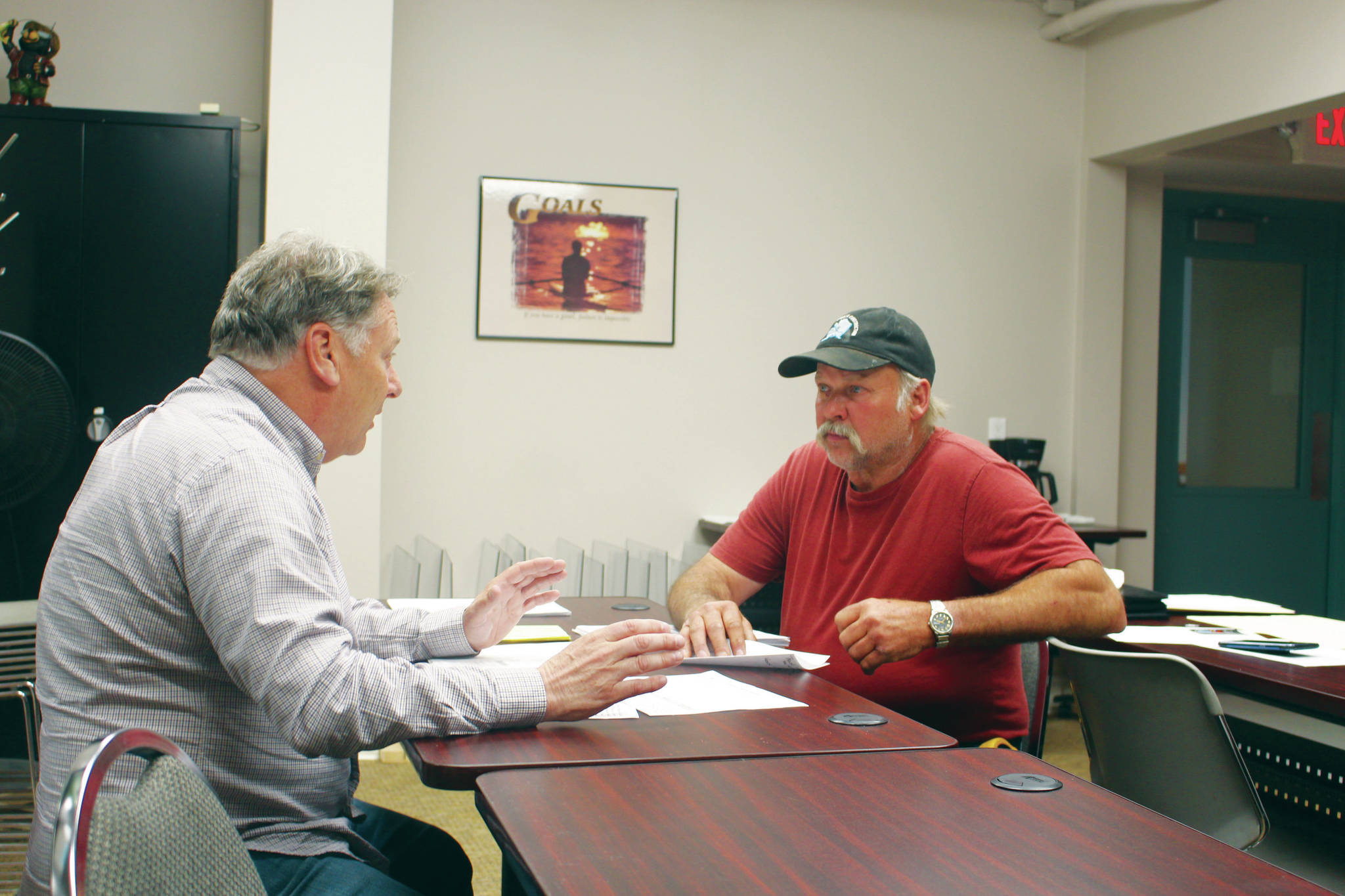 Tim Dillon, executive director of the Kenai Peninsula Economic Development District, helps Doug Weaver, owner of Northern Superior Construction, apply for an AK CARES grant through Credit Union 1 at the KPEDD office in Kenai on Wednesday. (Photo by Brian Mazurek/Peninsula Clarion)