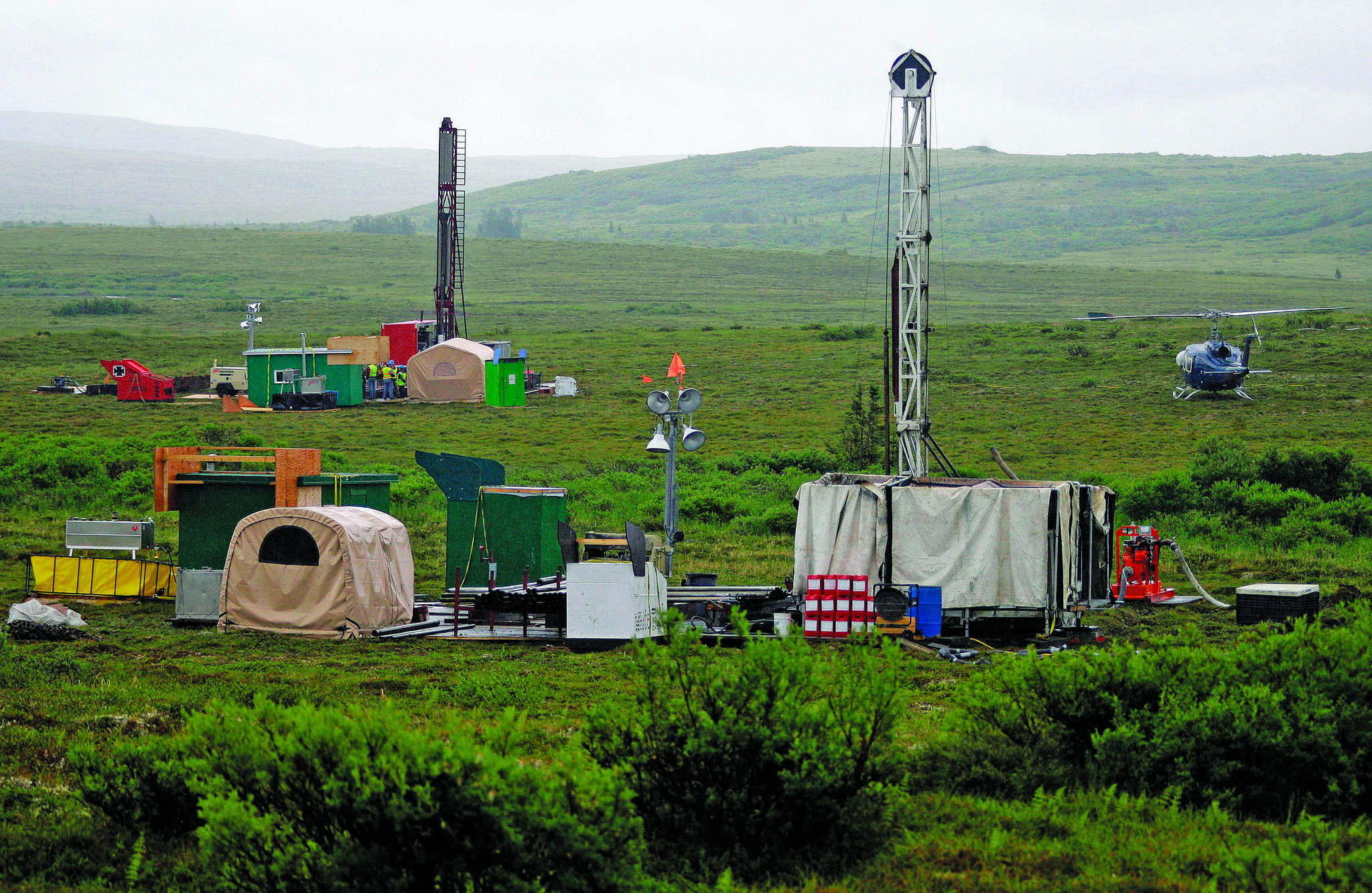 In this July 13, 2007, file photo, workers with the Pebble Mine project test drill in the Bristol Bay region of Alaska, near the village of Iliamma. The Pebble Limited Partnership, which wants to build a copper and gold mine near the headwaters of a major U.S. salmon fishery in southwest Alaska, says it plans to offer residents in the region a dividend. (AP Photo/Al Grillo, File)