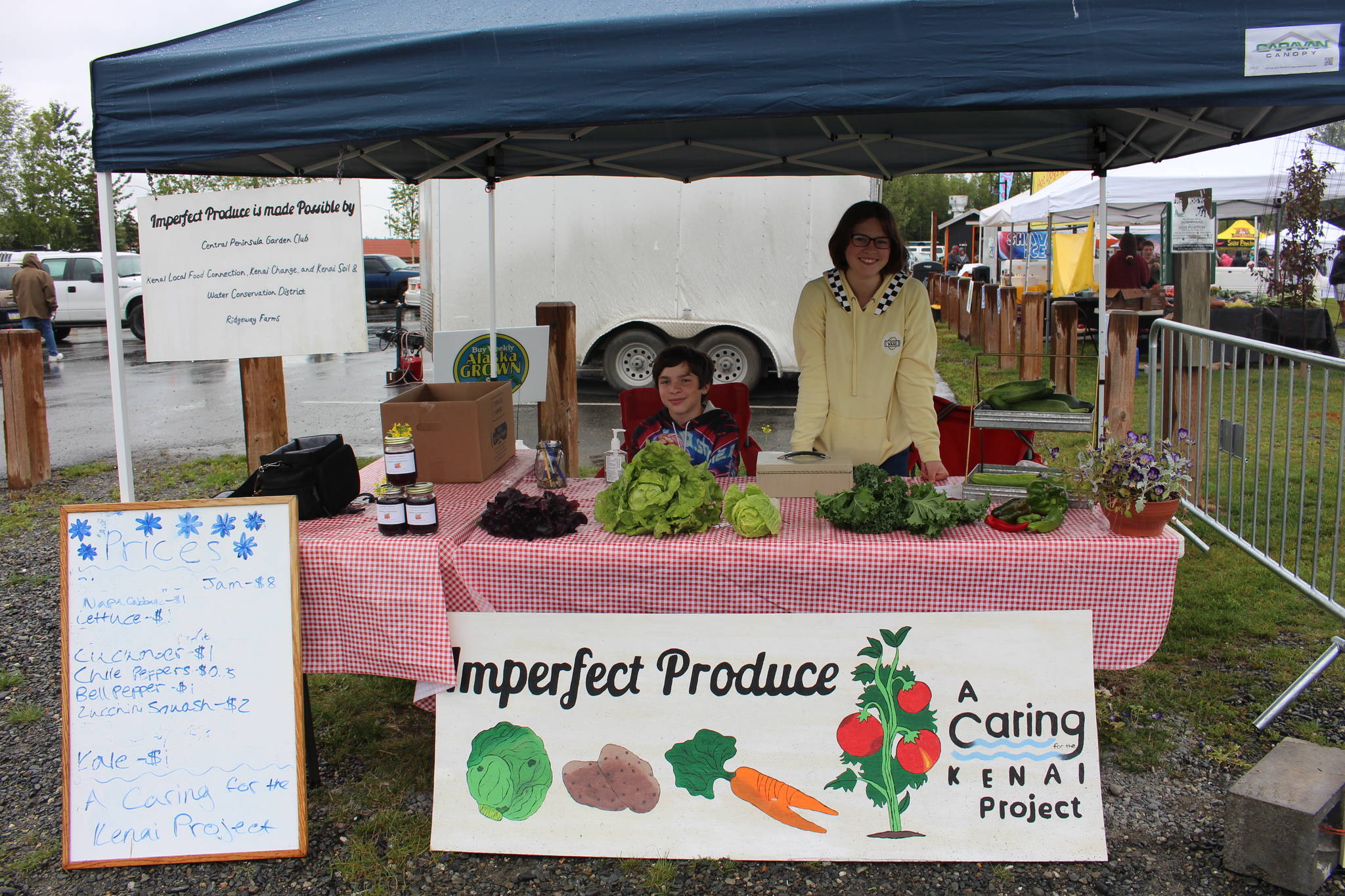 Nekoda Cooper, right, and Elijah Cooper, left, sell produce as part of Nekoda’s Caring for the Kenai Project, “Imperfect Produce”, during Progress Days in Soldotna Creek Park on July 22, 2020. (Photo by Brian Mazurek/Peninsula Clarion)