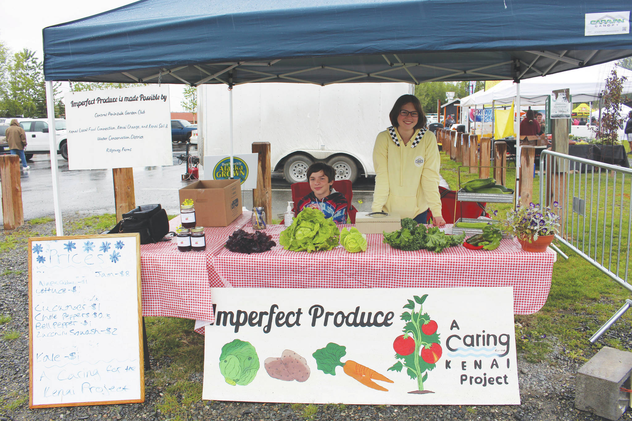 Photos by Brian Mazurek/Peninsula Clarion                                Nekoda Cooper, right, and Elijah Cooper, left, sell produce as part of Nekoda’s Caring for the Kenai Project, “Imperfect Produce,” during Progress Days in Soldotna Creek Park on Wednesday.