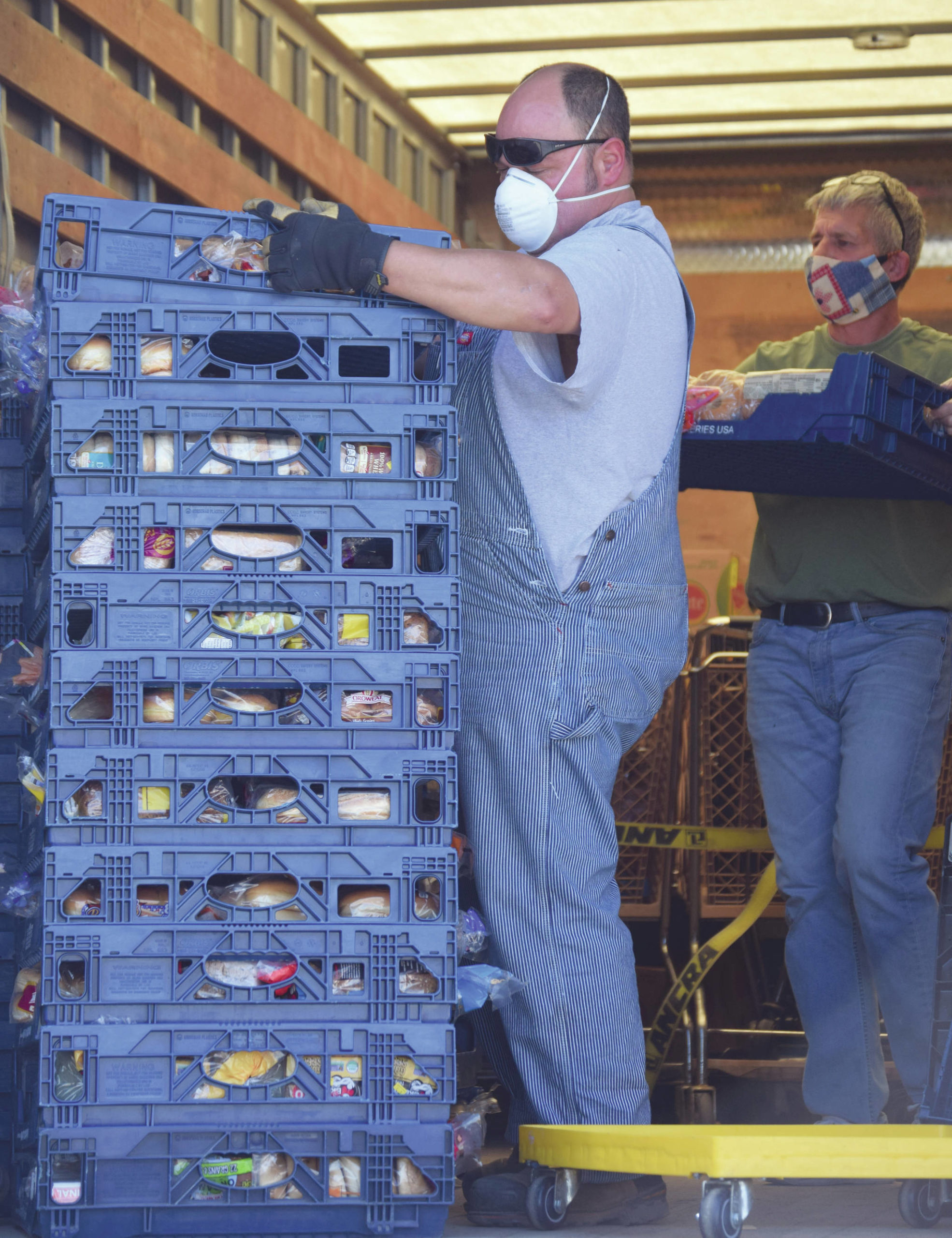 Jeff Helminiak / Peninsula Clarion                                John Webster and Duane Jennings with the Kenai Peninsula Food Bank unload a truck at the food bank just outside of Soldotna on Tuesday.