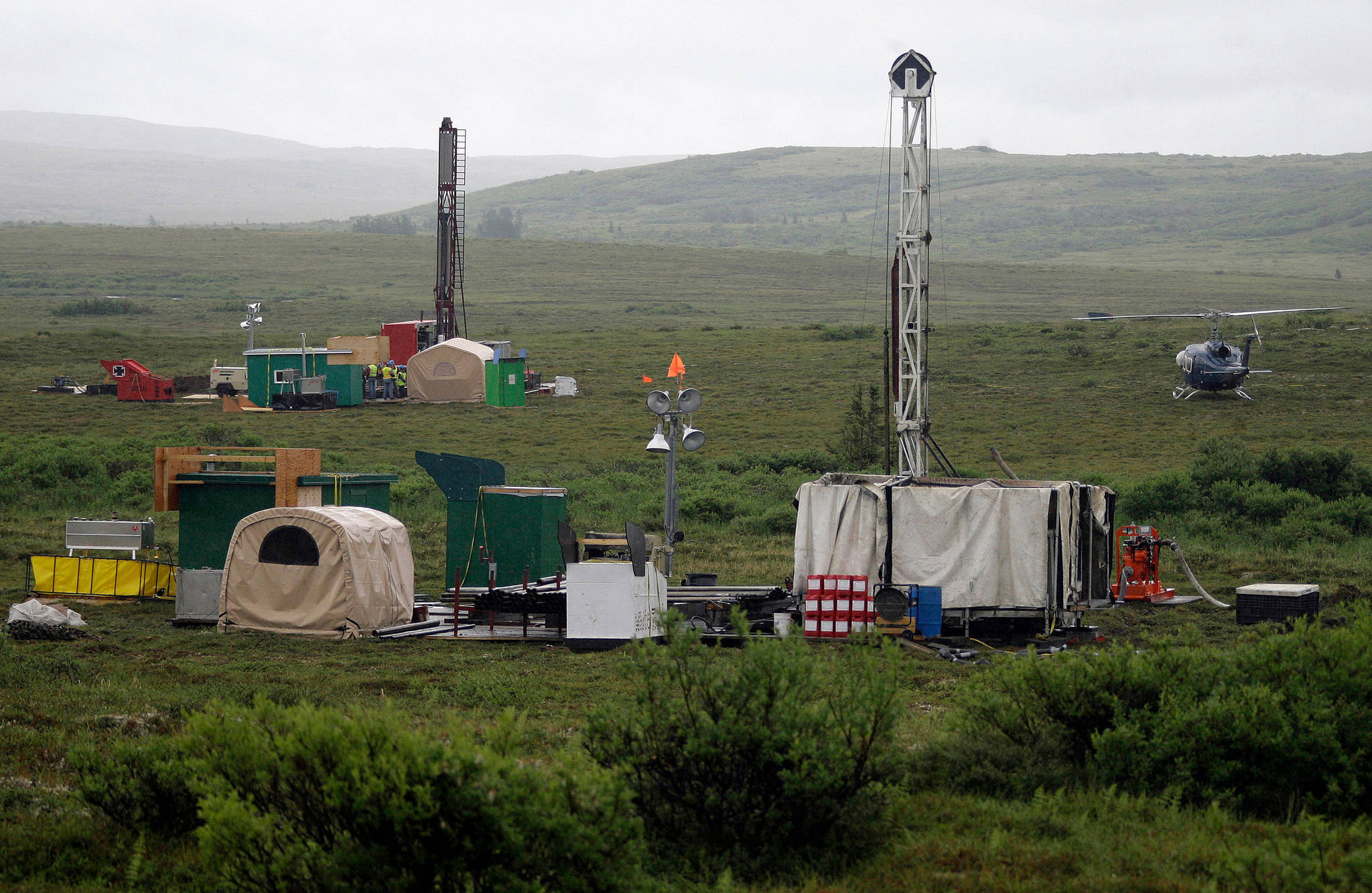 In this July 13, 2007, file photo, workers with the Pebble Mine project test drill in the Bristol Bay region of Alaska, near the village of Iliamma. The Pebble Limited Partnership, which wants to build a copper and gold mine near the headwaters of a major U.S. salmon fishery in southwest Alaska, says it plans to offer residents in the region a dividend. (AP Photo/Al Grillo, File)