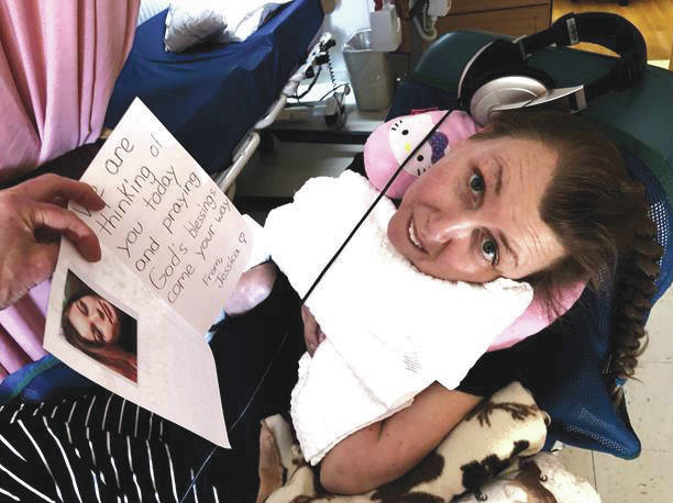 Resident Alisha Becker receives a card made by Jessica Geisler recently at Heritage Place in Soldotna, Alaska. (Photo provided by Aud Walaszek/Heritage Place)