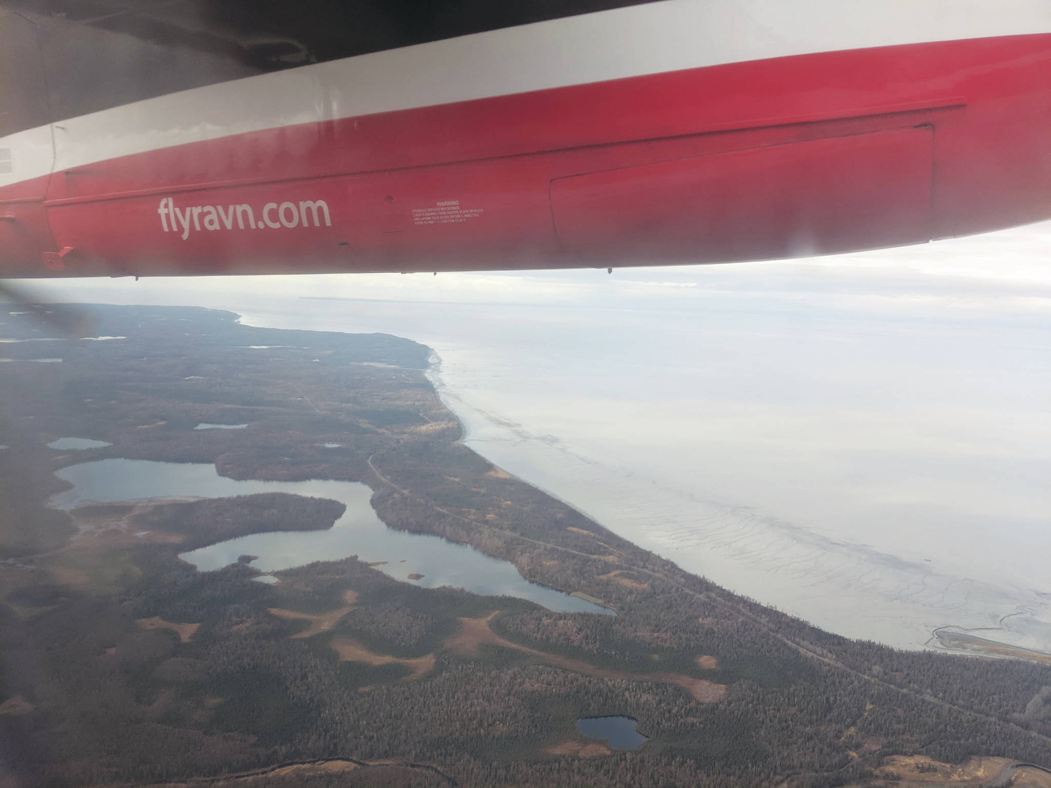 Erin Thompson / Peninsula Clarion                                 Cook Inlet can be seen through the window of a Ravn aircraft in October 2019. RavnAir Group declared bankruptcy in April.
