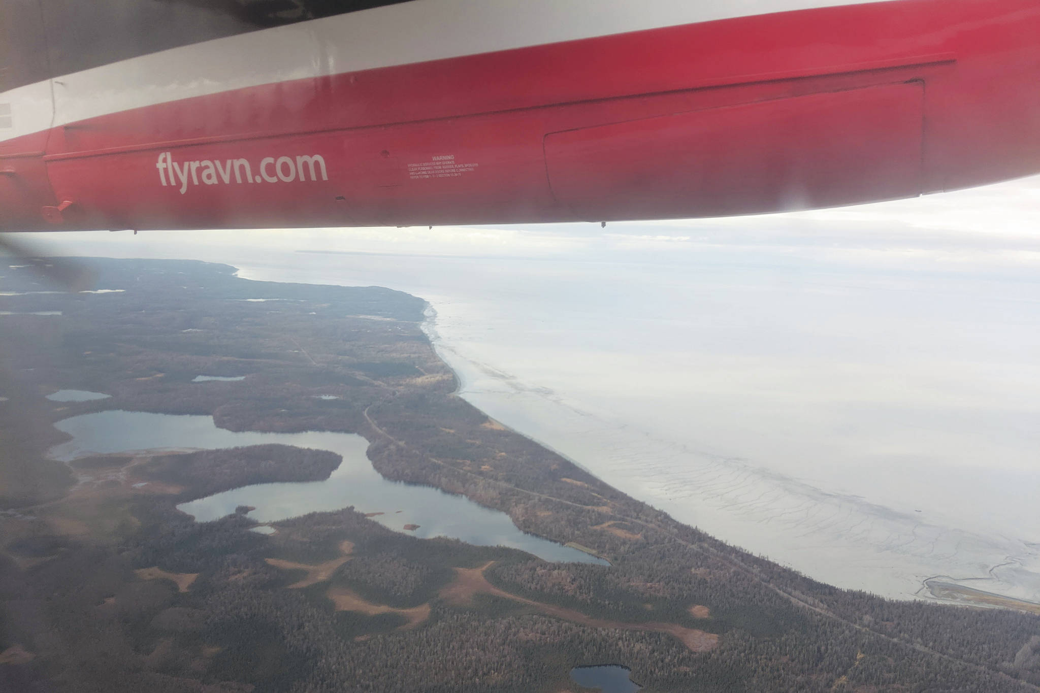 Cook Inlet can be seen through the window of a Ravn aircraft in October 2019. RavnAir Group declared bankruptcy in April. (Photo by Erin Thompson/Peninsula Clarion)