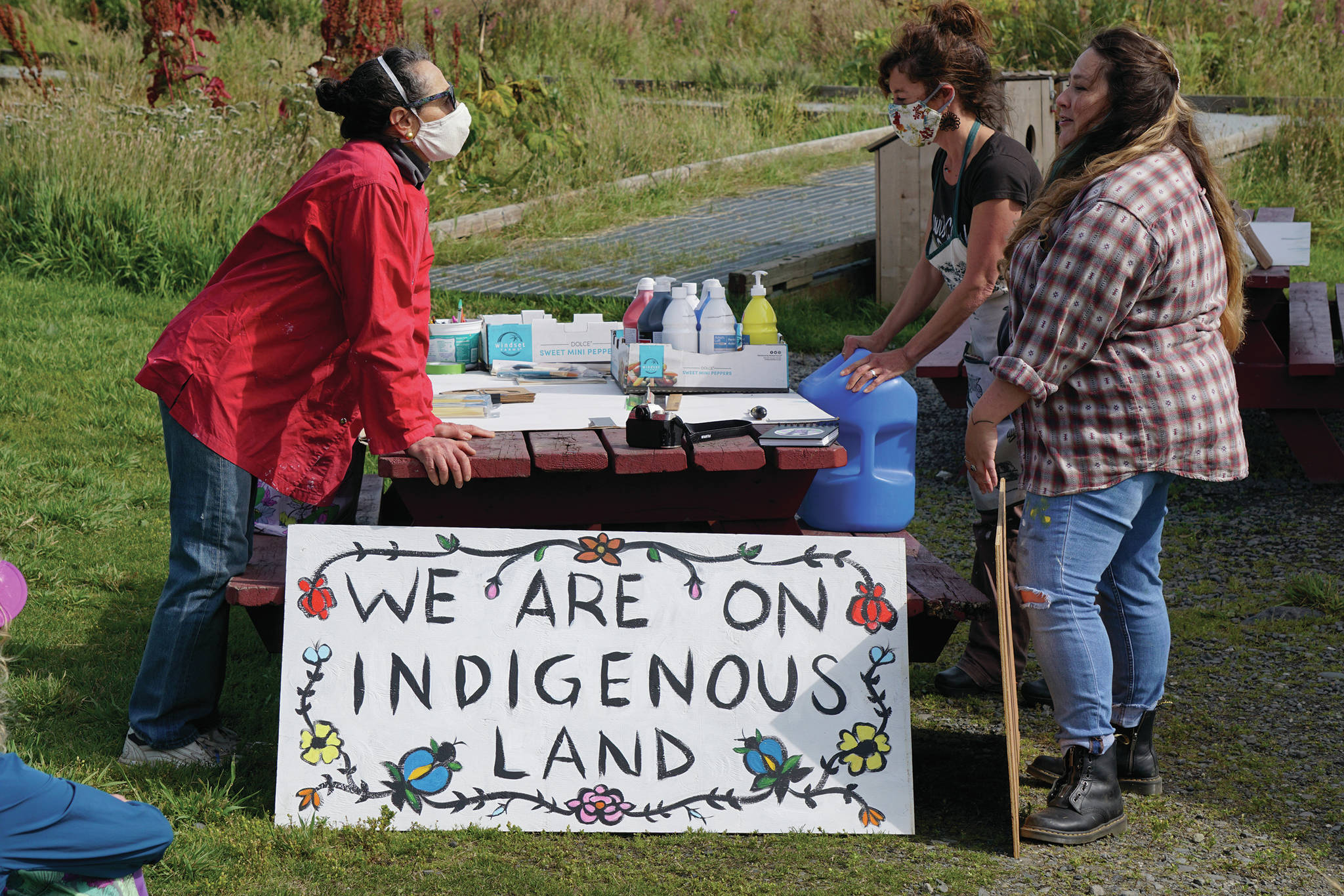 Melissa Shaginoff, right, speaks with Rika Mouw, left, and Asia Freeman, center, at “Land Acknowledgement in Action: Sign Installation” last Saturday at the Bishop’s Beach pavillion — the area known by the Dena’ina people as “Tuggeht,” or “at the water’s edge.”                                Michael Armstrong / Homer News