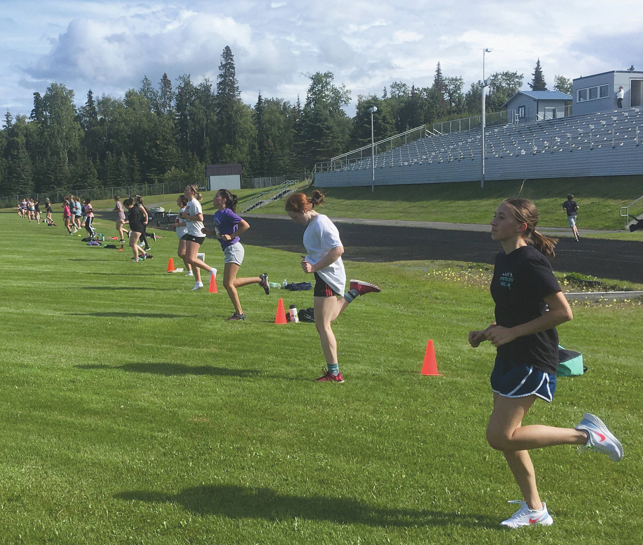 Photo by Jeff Helminiak/Peninsula Clarion                                 Juniors Alyssa Nunley (white shirt) and Rylee Ellis work out with the rest of their volleyball teammates Thursday at the football field at Nikiski High School in Nikiski.