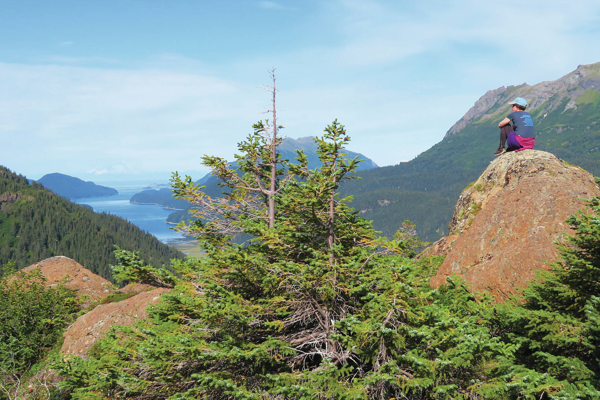 From a perch on Lunch Mountain, a hiker enjoys the sunshine and the view of Tutka Bay on the Tutka Backdoor Trail in Kachemak Bay State Park. (Photo by Clark Fair for the Peninsula Clarion)