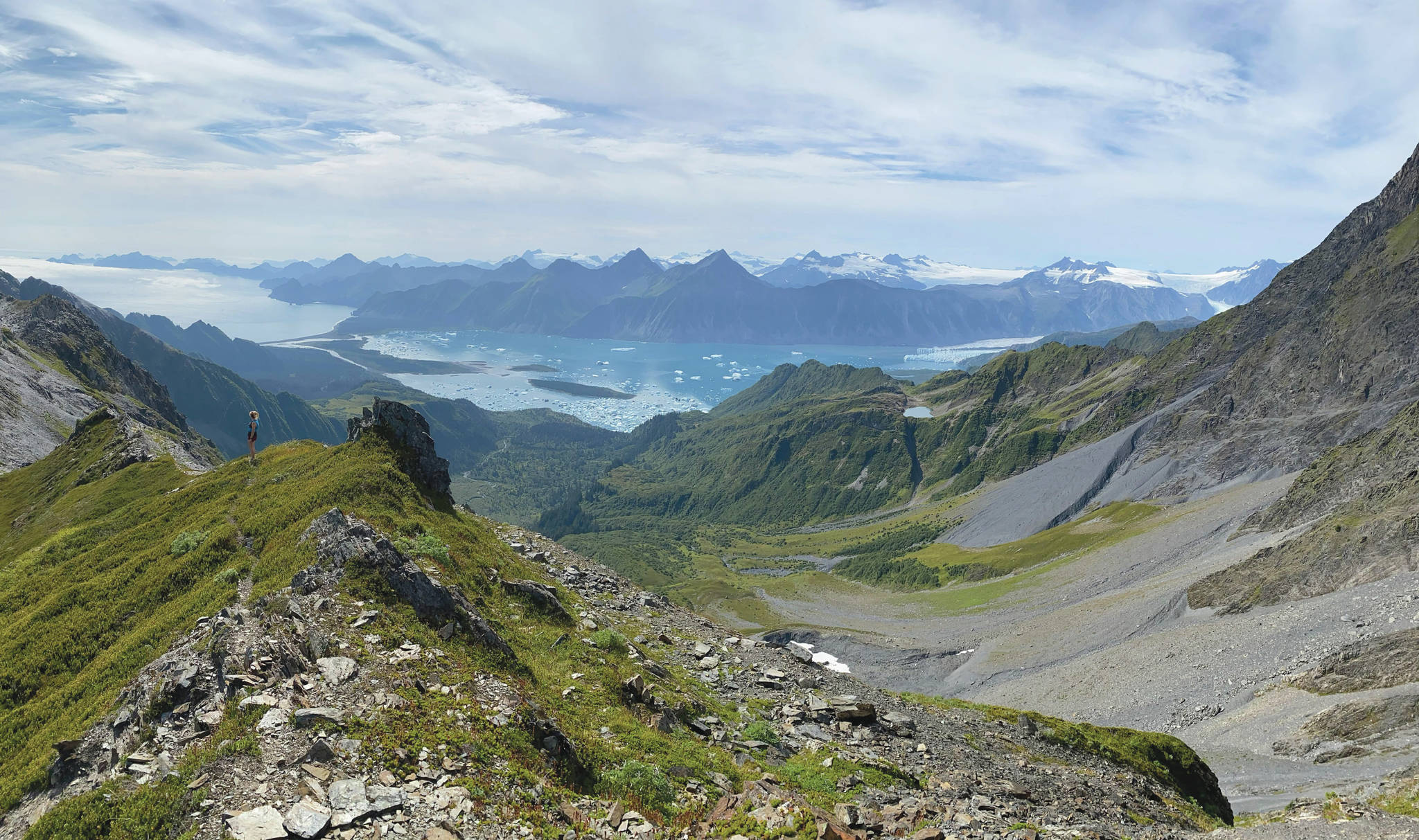 Kat Sorensen can be seen on the ridgeline overlooking Bear Glacier Lagoon. (Photo courtesy of Collin Atkinson)