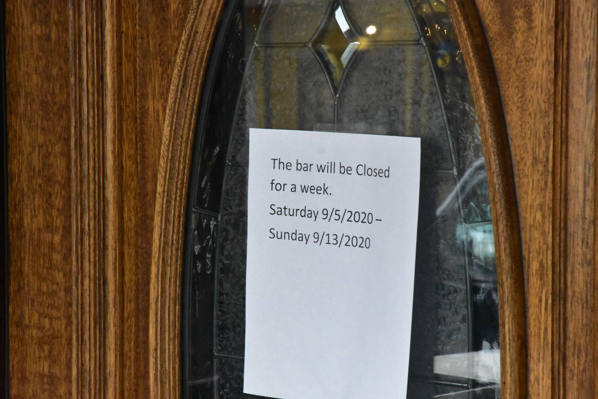 A sign on the doors of the Alaskan Hotel and Bar in downtown Juneau letting customers know of a temporary closure. Several bars downtown voluntarily closed their doors recently after an outbreak of COVID-19 among bar workers. Wednesday, Sept. 9, 2020. (Peter Segall / Juneau Empire)