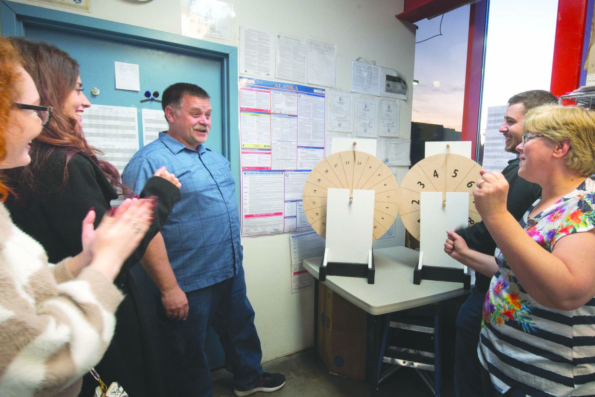 Police Chief David Ross spins the Magic Weight wheels at Three Bears on Saturday, Sept. 14, 2019, with a crowd cheering the results of the Kenai Silver Salmon Derby in Kenai, Alaska. (Photo Divining Point, LLC)