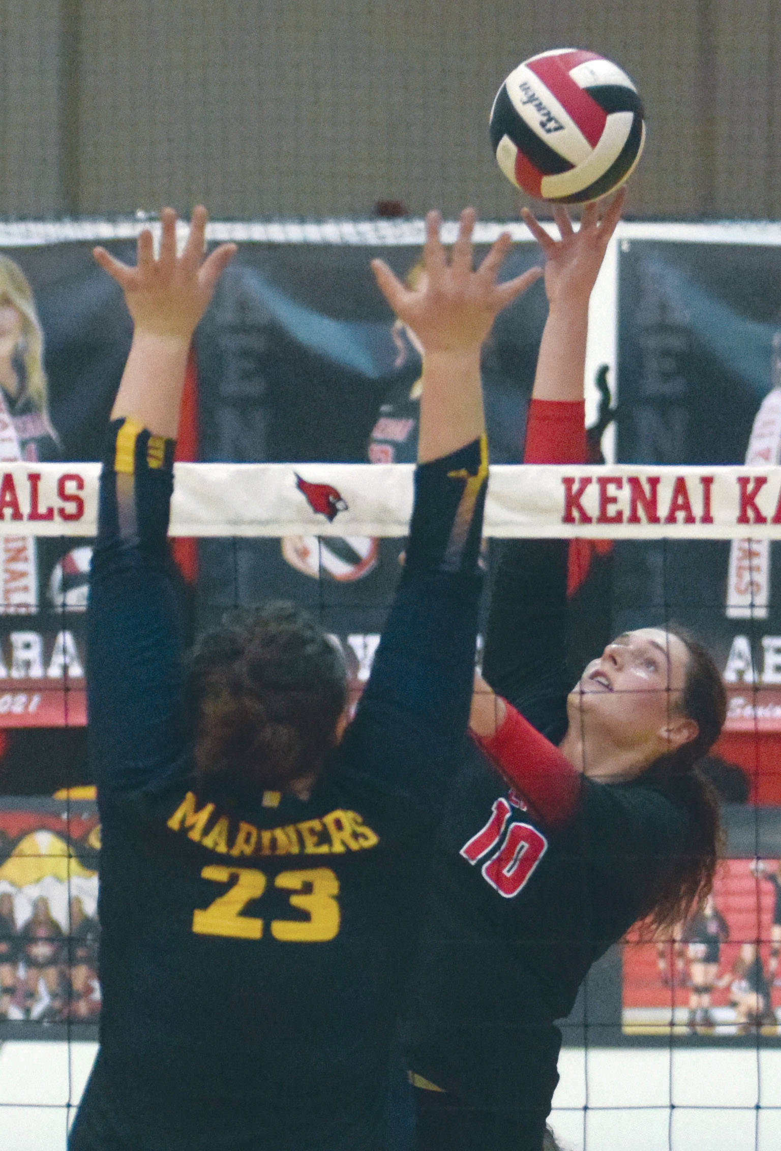 Kenai Central’s Abby Every tips over Homer’s Tonda Smude on Friday, Sept. 18, 2020, at Kenai Central High School in Kenai, Alaska. (Photo by Jeff Helminiak/Peninsula Clarion)