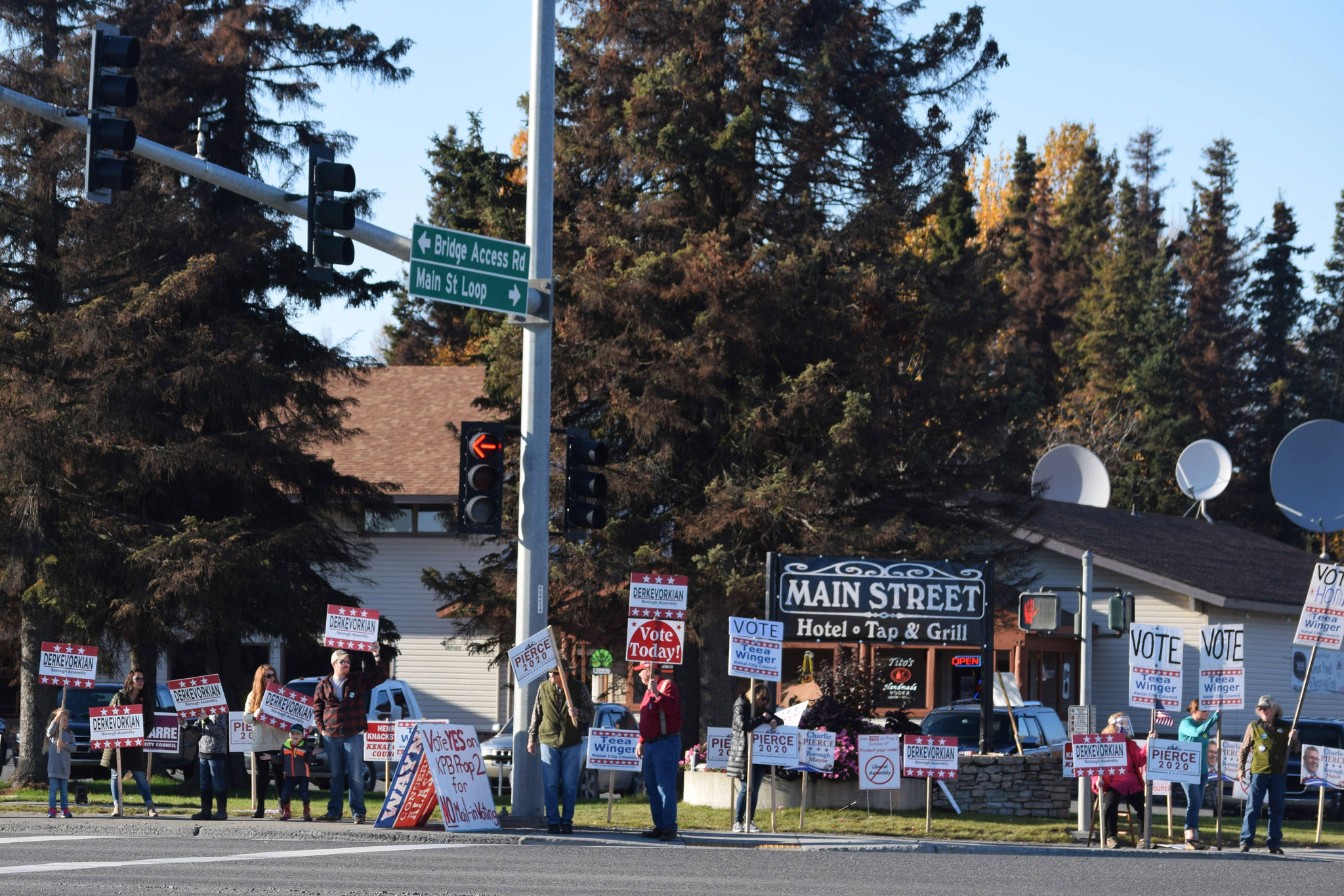 Supporters hold campaign signs at the intersection of Main St. Loop and Kenai Spur Highway in Kenai, Alaska, on Tuesday, Oct. 6. (Photo by Ashlyn O’Hara/Peninsula Clarion)