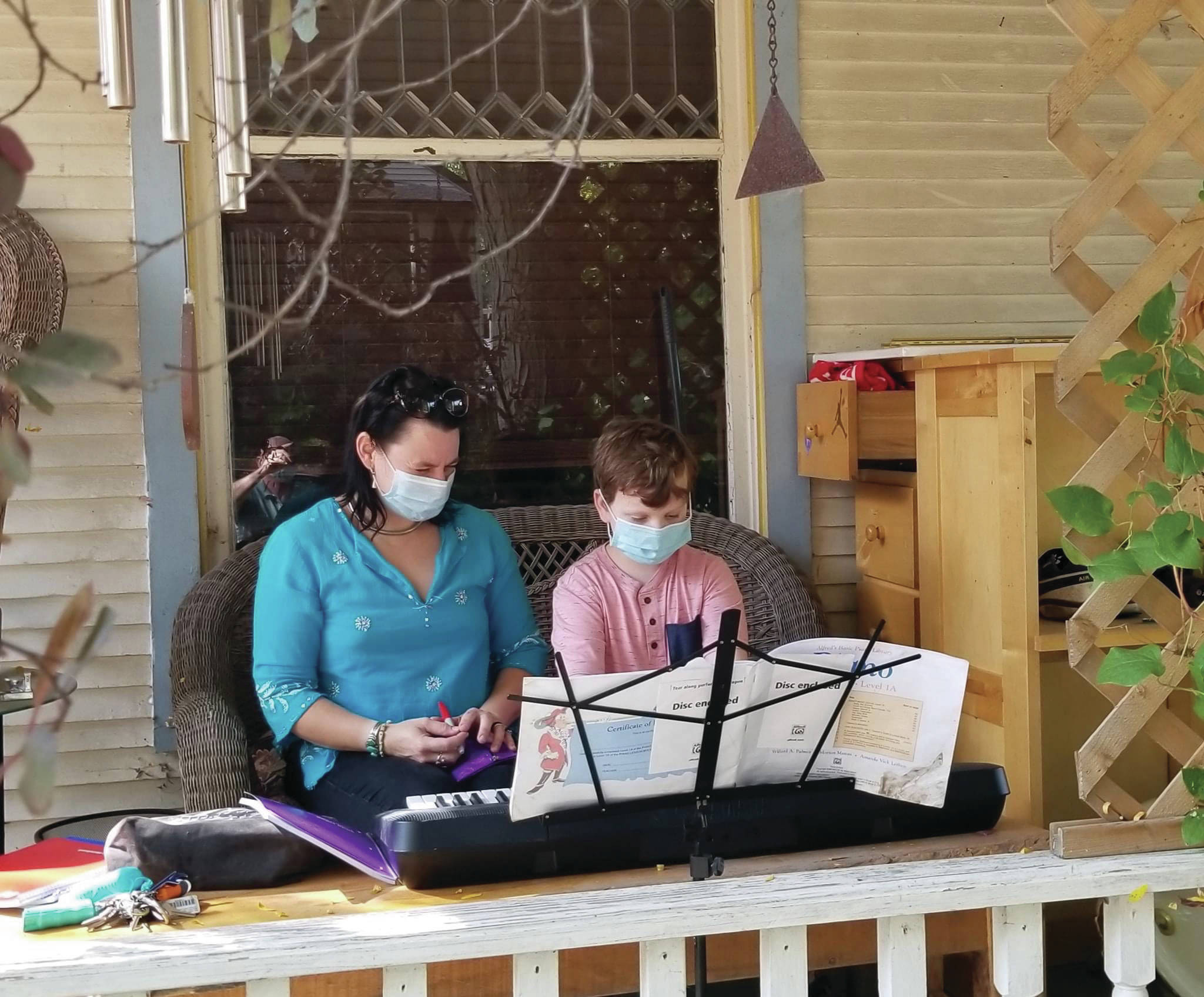 Willy Talbot and his piano teacher Angela McJunkin resume piano lessons on the family’s deck, on Sept. 23, 2020, in Madison, Wisconsin. The photo was submitted for “Behind the Mask - Our Stories.” (Photo by Terry Talbot; courtesy of Christina Whiting)