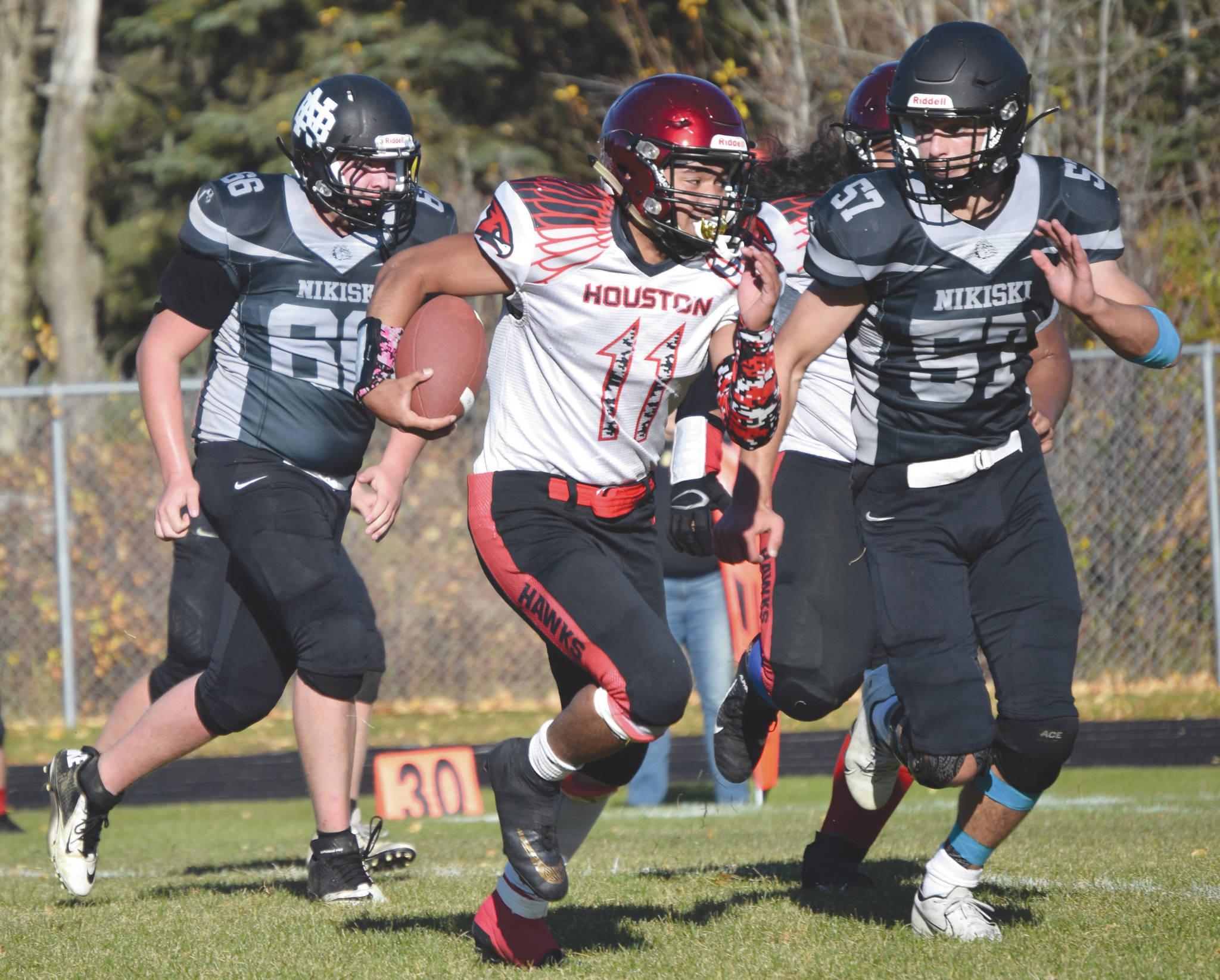 Houston’s Tolupo Falaniko is chased by Nikiski’s Caileb Payne on Saturday, Oct. 10, 2020, at Nikiski High School in Nikiski, Alaska. (Photo by Jeff Helminiak/Peninsula Clarion)