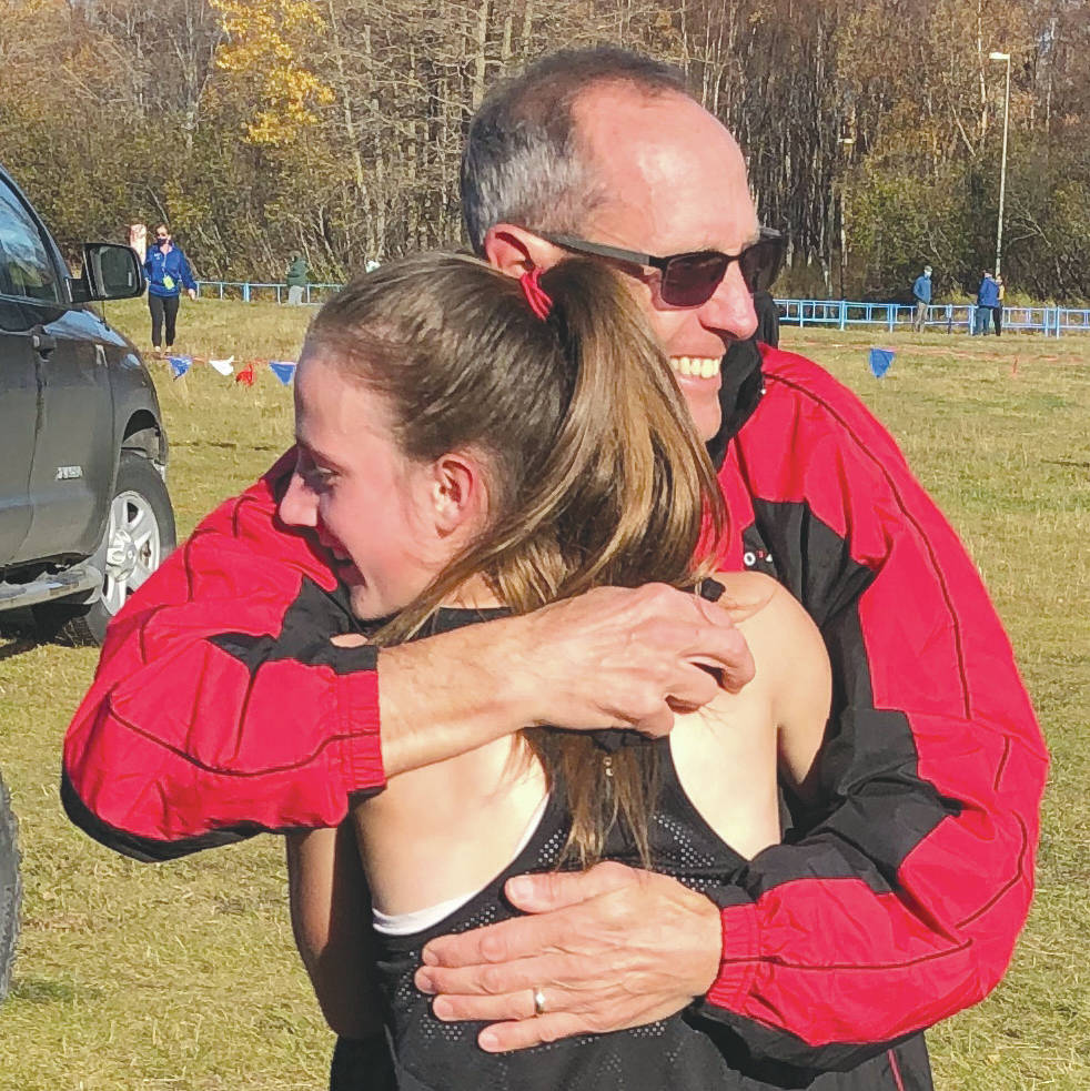 Kenai Central’s Jayna Boonstra receives a hug from father and Kardinals coach, Todd Boonstra, Saturday, Oct. 10, 2020, at the ASAA cross-country running championships at Kincaid Park in Anchorage, Alaska. (Photo by Joey Klecka)