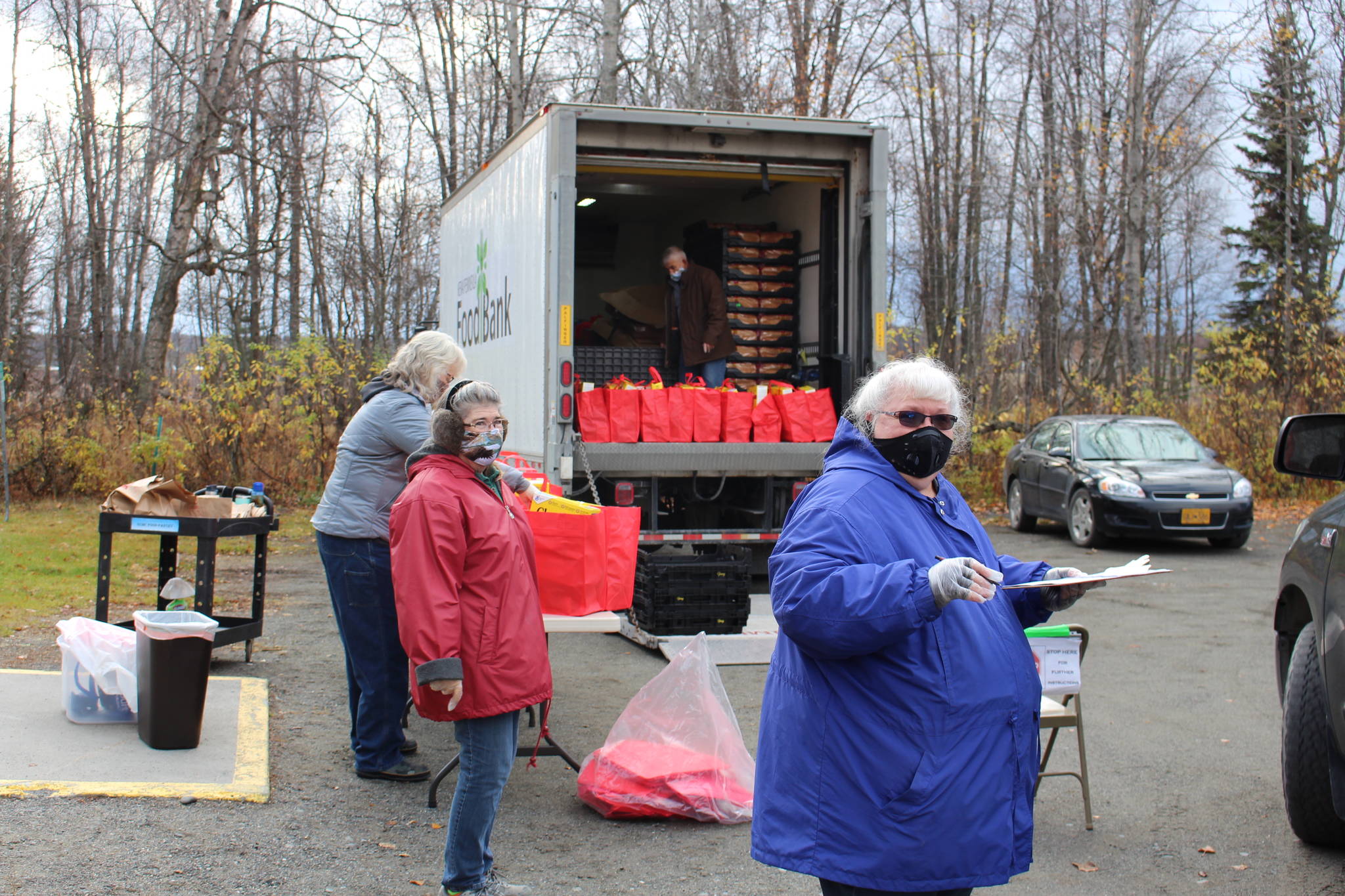Volunteers distribute bags of food for Soldotna Residents thanks to a grant program from the city at the Soldotna United Methodist Church on Oct. 14, 2020. From left: Cosette Kilfoyle, Director of the Soldotna Food Pantry; Sandy Sandoval and Leroy Sandoval, Food Bank Volunteers; Kathy Carson, member of Christ Lutheran Church. (Photo by Brian Mazurek/Peninsula Clarion)