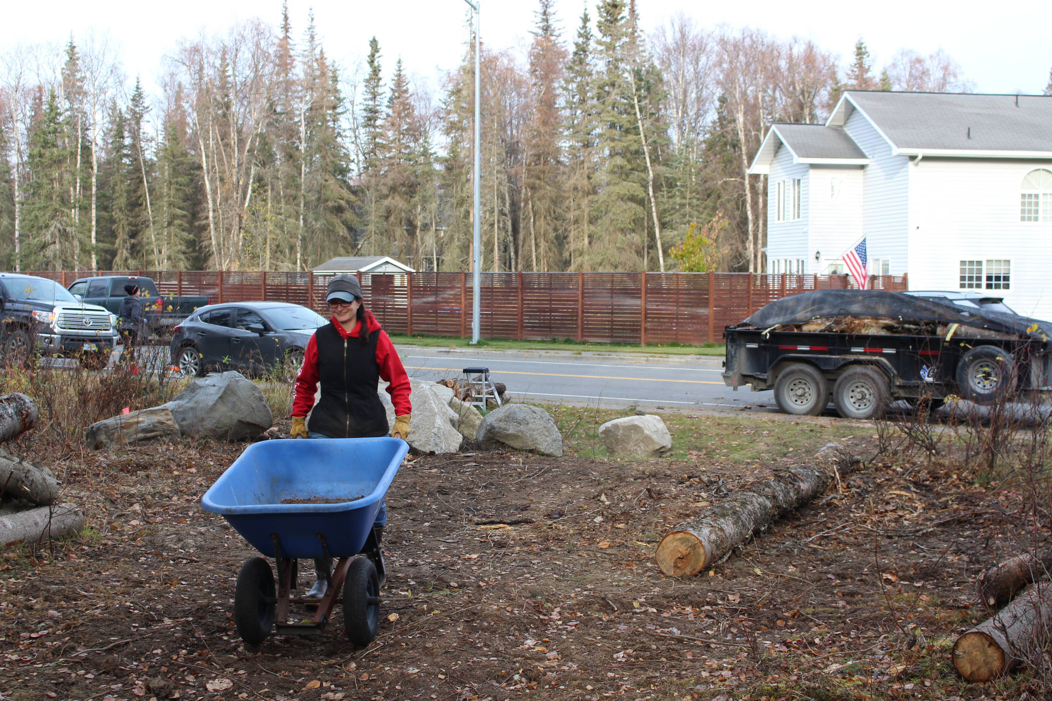 Sarah Pyhala, president of the board for the Shimai Toshi Garden Trails, which is spearheading the Kenai Peninsula Peace Crane Garden Trail, pushes a wheelbarrow while she and other volunteers clear the trail on Marydale Avenue in Soldotna, Alaska, on Oct. 17, 2020. (Photo by Brian Mazurek/Peninsula Clarion)