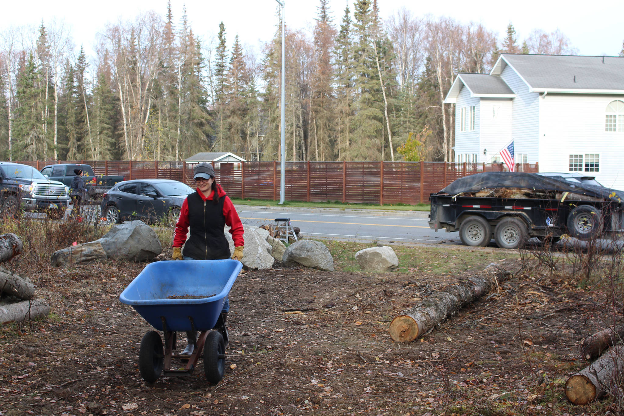 Sarah Pyhala, president of the board for the Shimai Toshi Garden Trails, which is spearheading the Kenai Peninsula Peace Crane Garden Trail, pushes a wheelbarrow while she and other volunteers clear the trail on Marydale Avenue in Soldotna, Alaska, on Oct. 17, 2020. (Photo by Brian Mazurek/Peninsula Clarion)