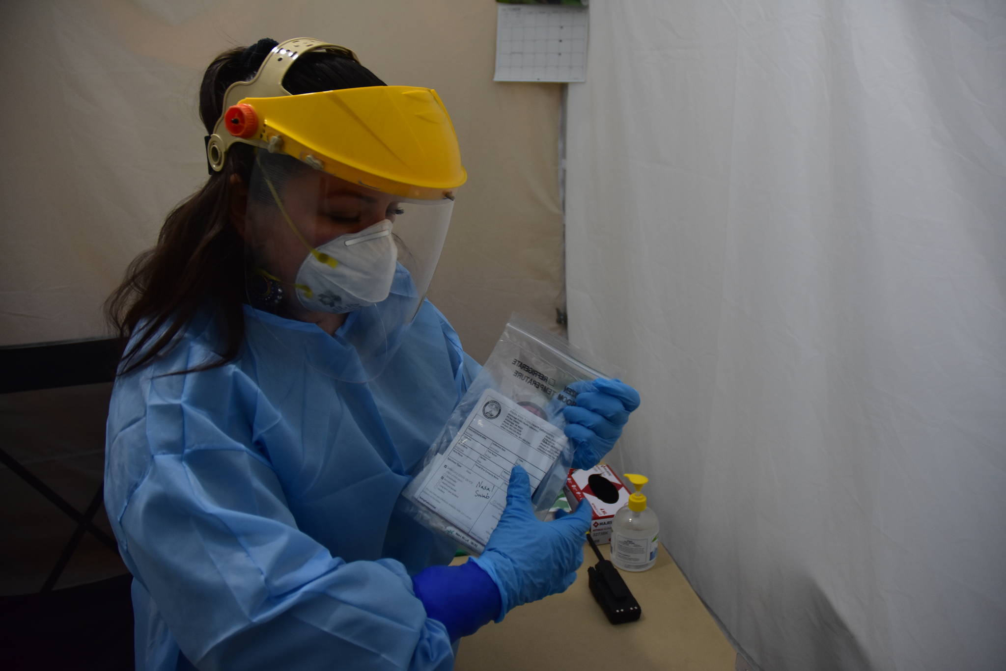 Emergency worker Melanie Chavez takes a COVID-19 test sample at the Juneau International Airport screening site on Monday, Oct. 12, 2020. The City and Borough of Juneau raised its health alert level Tuesday as the number of cases grows locally and statewide. (Peter Segall / Juneau Empire)
