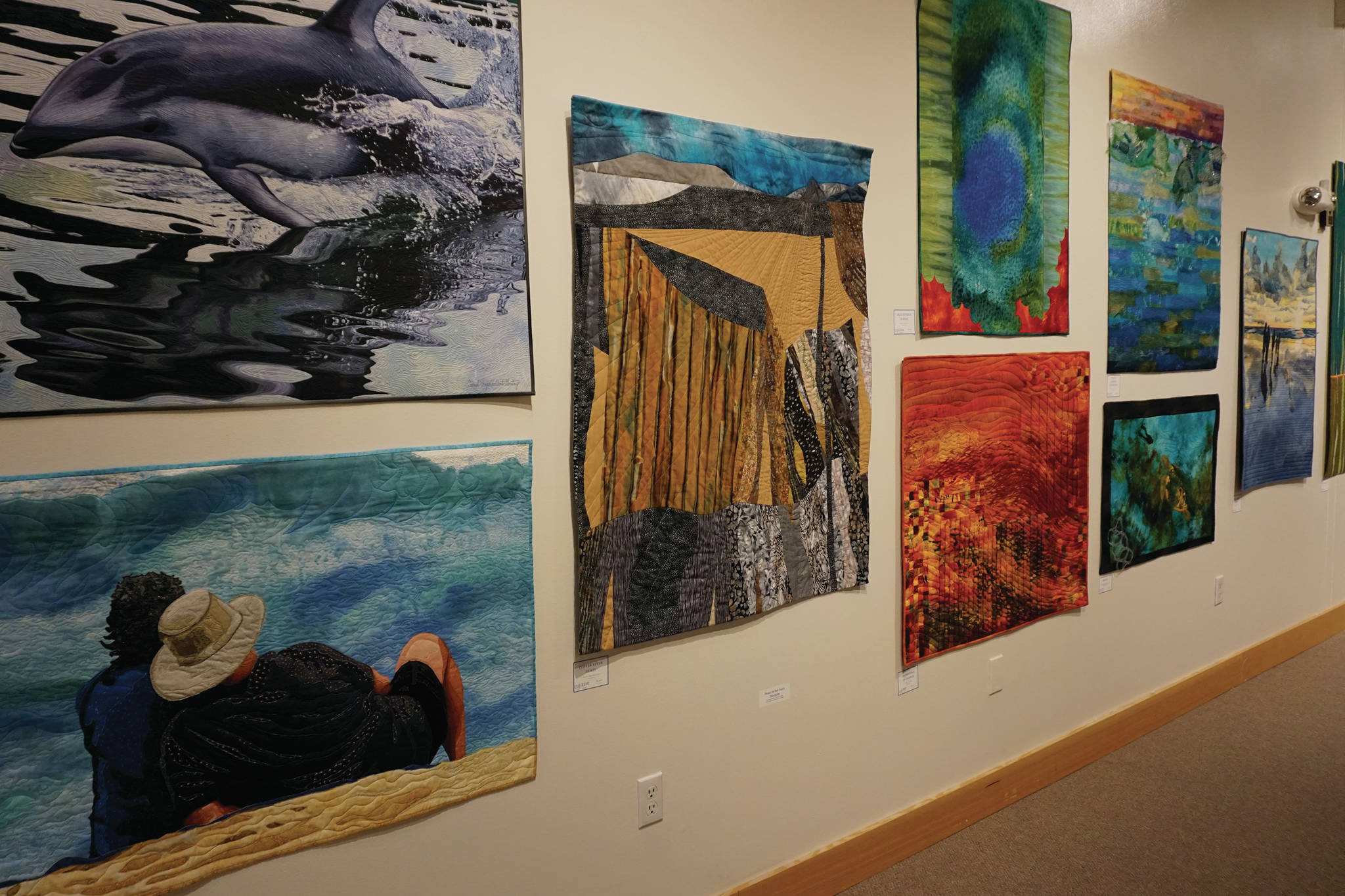 Some of the 45 art quilts featured in "Shifting Tides: Cloth in Convergence," on exhibit from Oct. 9 to Nov. 28, 2020, at the Pratt Museum in Homer, Alaska. (Photo by Michael Armstrong/Homer News)