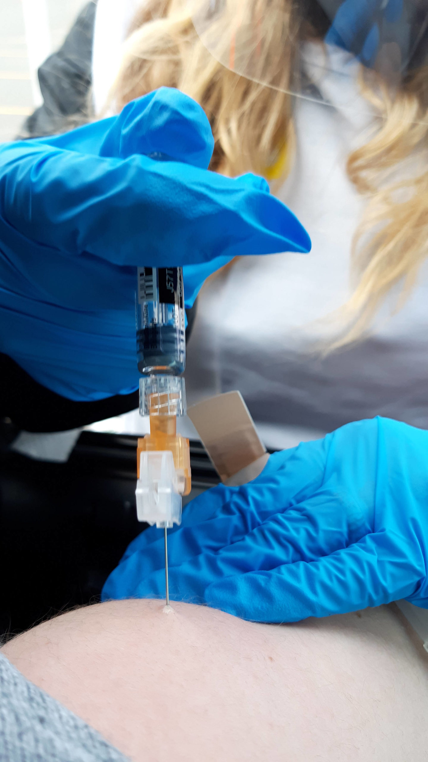 Chelsea Berg, a nurse at Peninsula Community Health Services, administers a flu shot during a free drive-thru flu shot event at Kenai Central High School in Kenai, Alaska, on Saturday, Oct. 24, 2020. (Photo by Brian Mazurek/Peninsula Clarion)