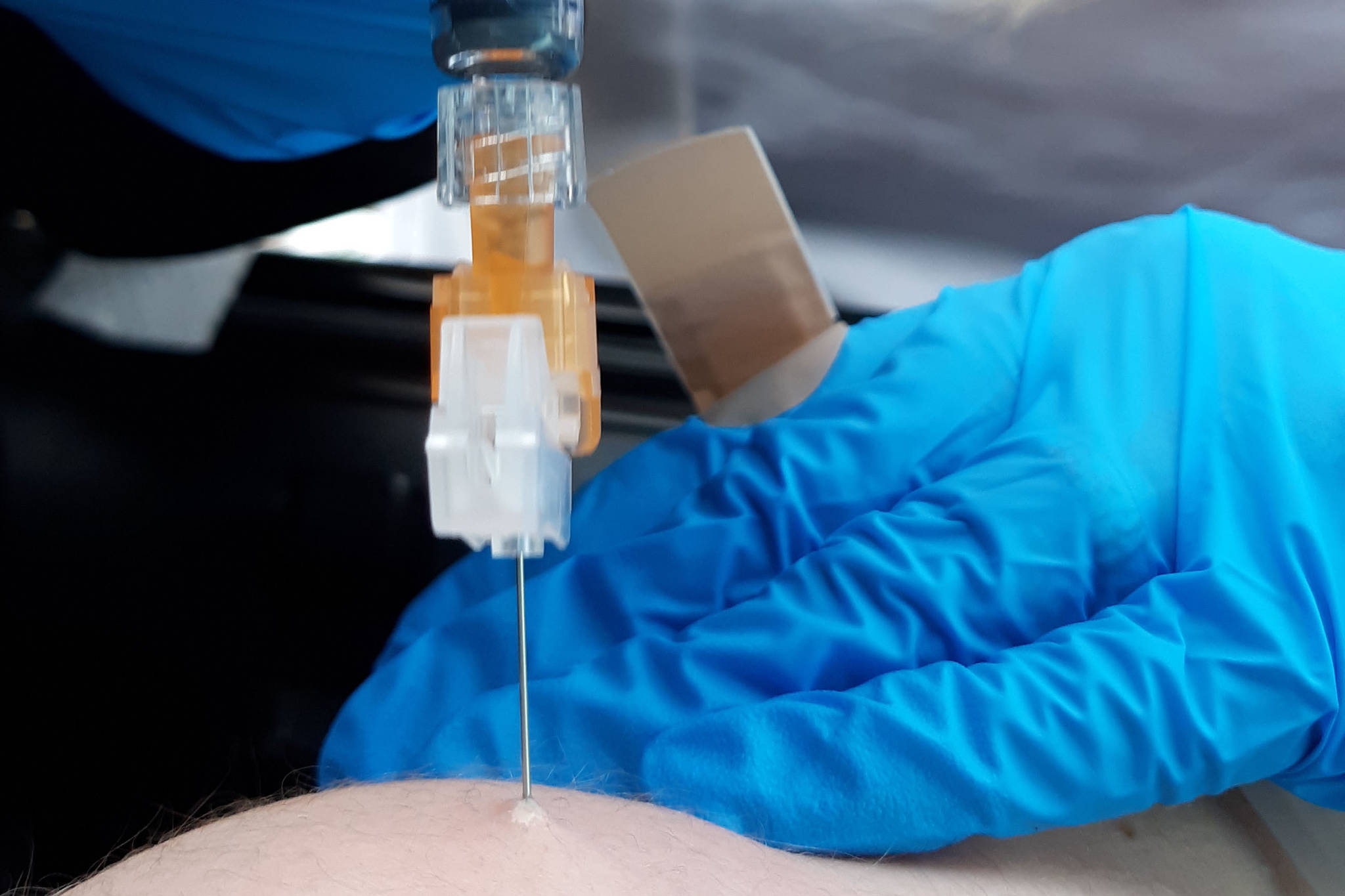 Chelsea Berg, a nurse at Peninsula Community Health Services, administers a flu shot during a free drive-thru flu shot event at Kenai Central High School in Kenai, Alaska, on Saturday, Oct. 24, 2020. (Photo by Brian Mazurek/Peninsula Clarion)