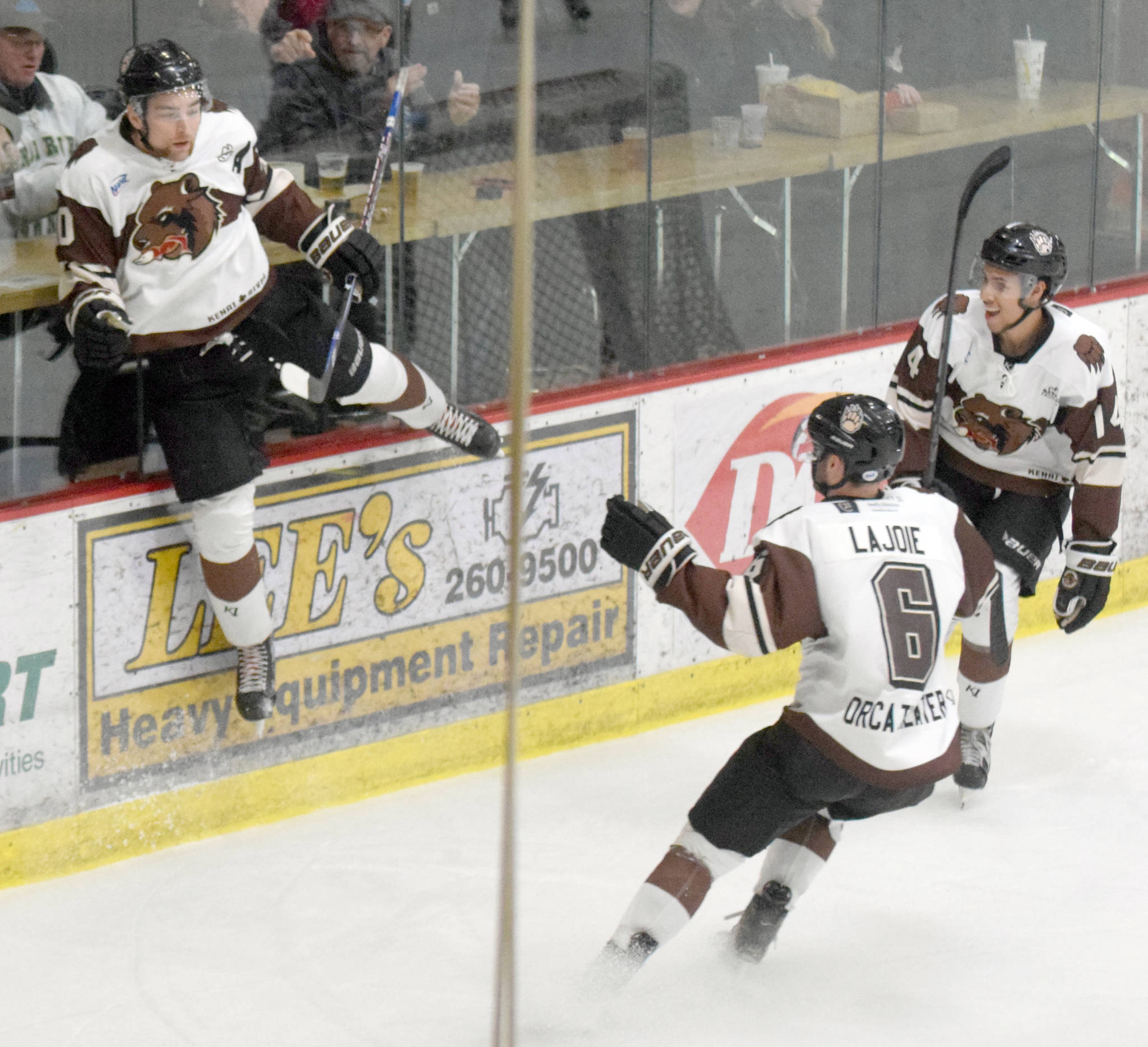 Kenai River Brown Bears forward Laudon Poellinger jumps on the boards to celebrate his first-period goal against the Fairbanks Ice Dogs with Brandon Lajoie and Ryan Reid at the Soldotna Sports Center in Soldotna, Alaska. (Photo by Jeff Helminiak/Peninsula Clarion)