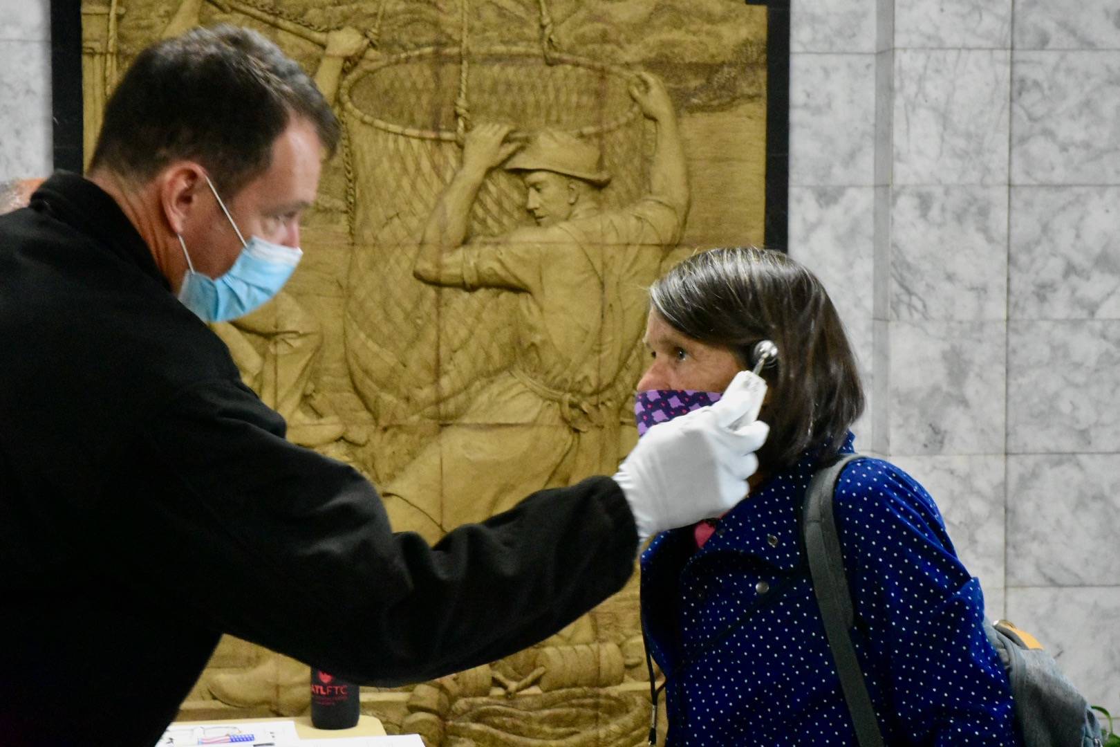 Peter Segall / Juneau Empire File 
Rep. Jennifer Johnston, R-Anchorage, gets her temperature taken as she enters the Alaska State Capitol on Monday, May 18.