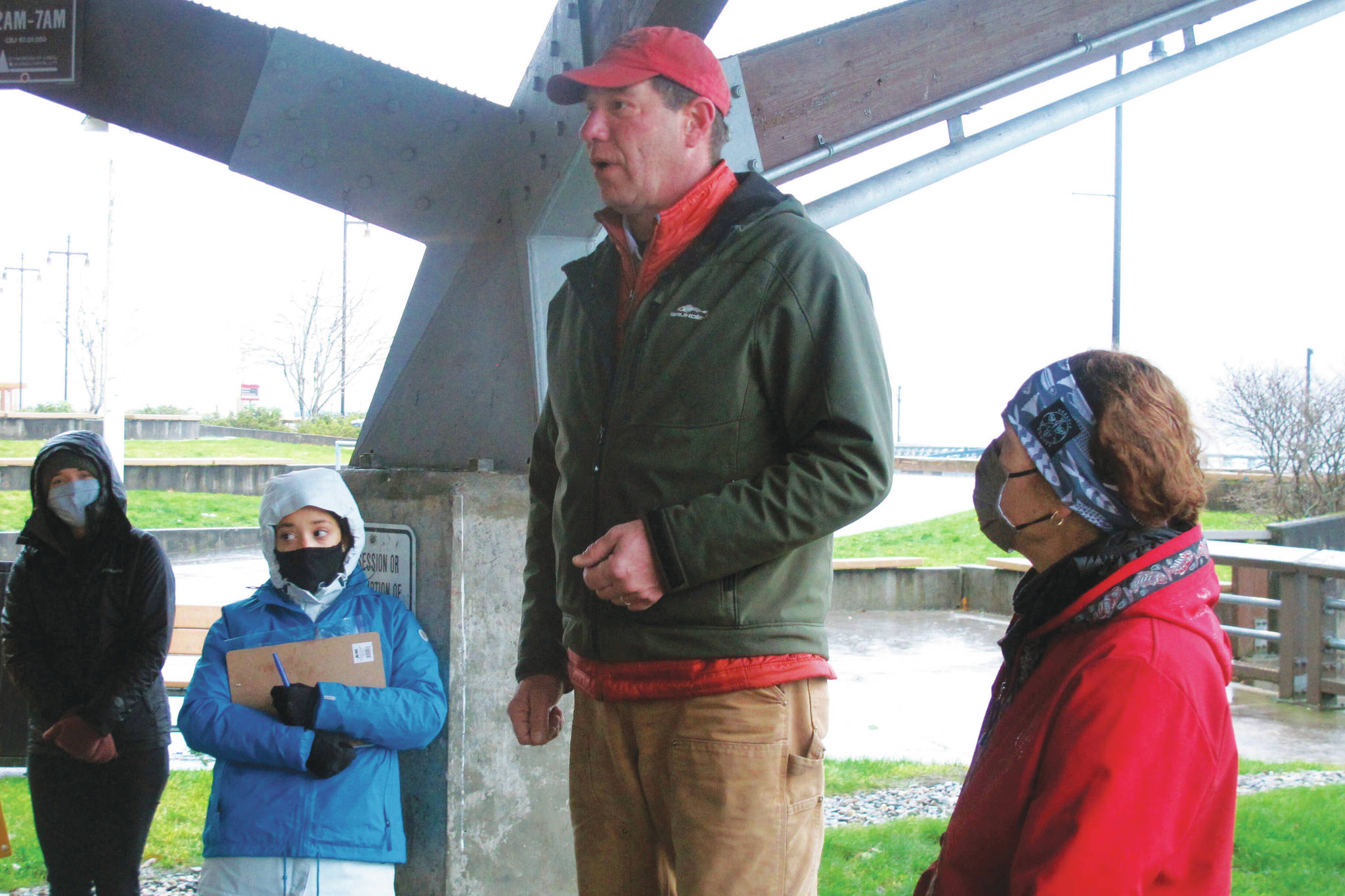 Alaska U.S. Senate candidate Al Gross speaks to supporters at an event at a downtown park in Juneau, Alaska, on Saturday, Oct. 31, 2020, as his wife, Monica Gross, at right, looks on. The event, held on a rainy, windy morning, is among those Gross is holding in the lead-up to the Nov. 3, 2020, general election, in which Gross, an independent running with Democratic backing, is facing Republican U.S. Sen. Dan Sullivan. (AP Photo/Becky Bohrer)