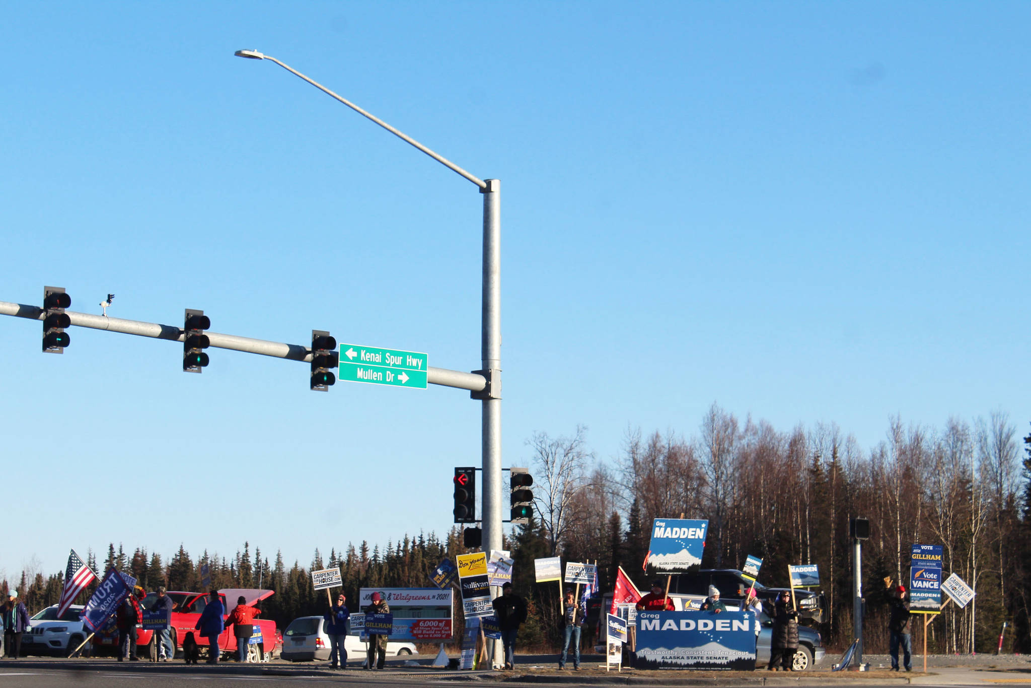 Supporters hold campaign signs at the intersection of Sterling Highway and Kenai Spur Highway on Tuesday, Nov. 3 in Soldotna, Alaska. (Photo by Ashlyn O’Hara/Peninsula Clarion)