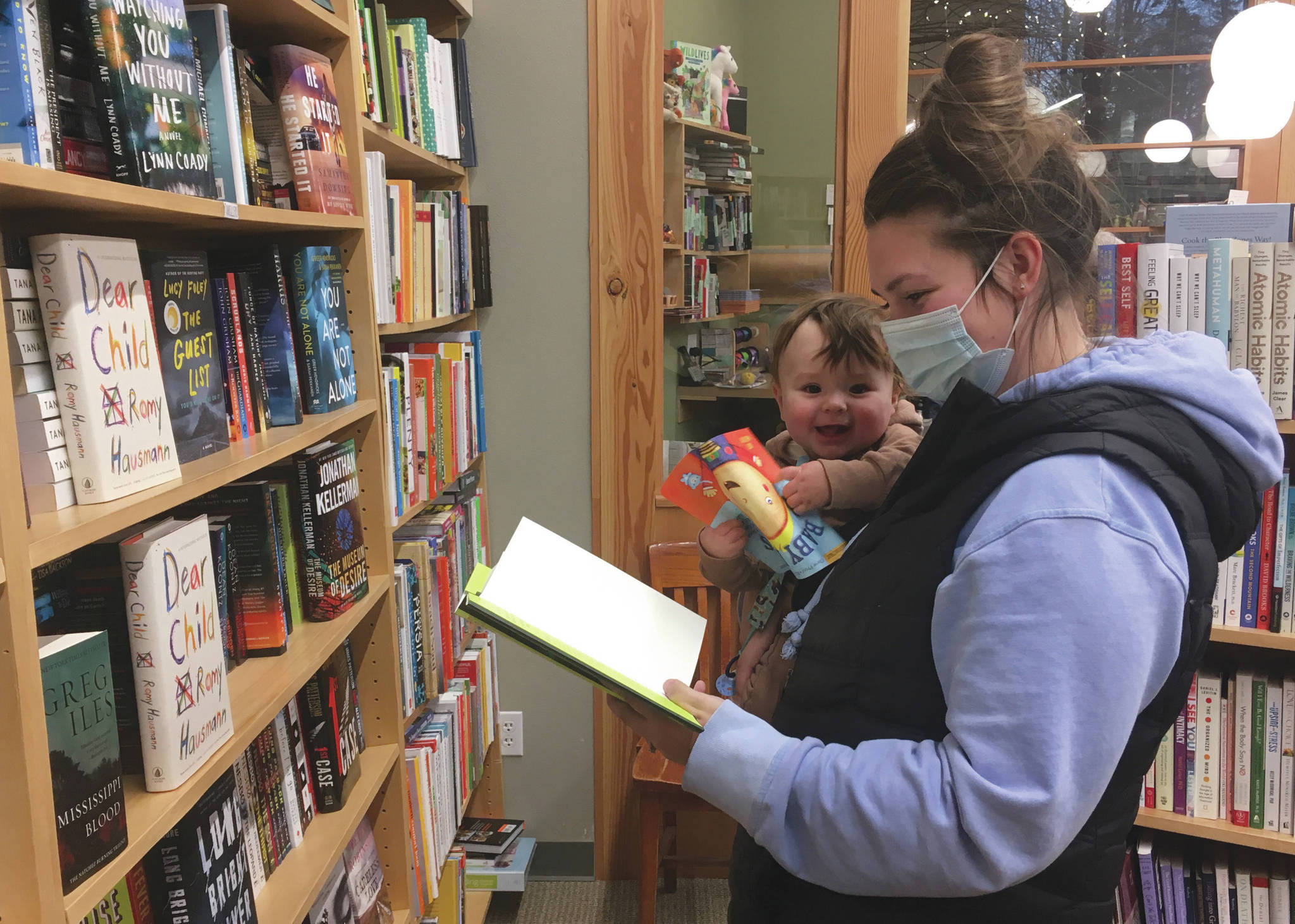 Photo by Jeff Helminiak / Peninsula Clarion 
Jessie Duke, of Soldotna, browses books Monday with 7-month-old Danny Dommek at River City Books in Soldotna.