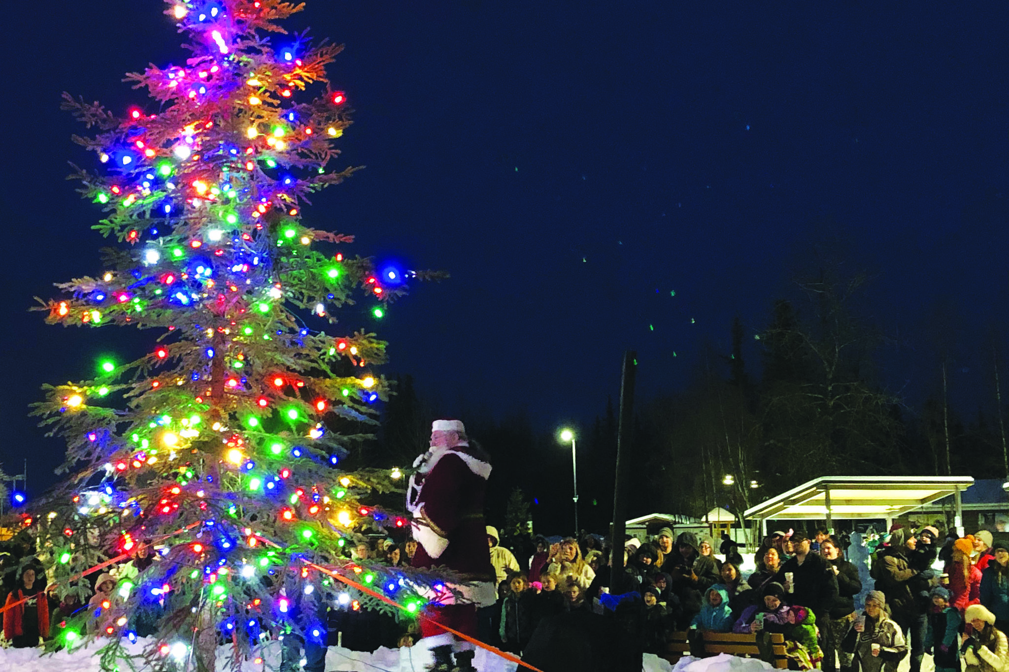 Santa Claus lights up the Christmas tree in front of an audience Saturday, Dec. 7, 2019, at the Christmas in the Park Celebration at Soldotna Creek Park in Soldotna, Alaska. (Photo by Joey Klecka/Peninsula Clarion)